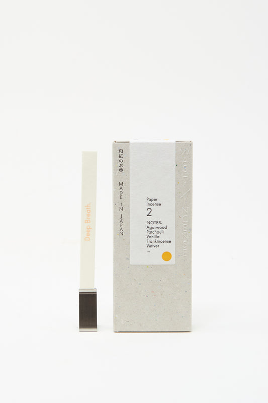 Morihata's "Washi Paper Incense Strips in Elegant Agarwood" features delicate strips with notes of agarwood, vanilla, frankincense, and vetiver, accompanied by a metal holder.