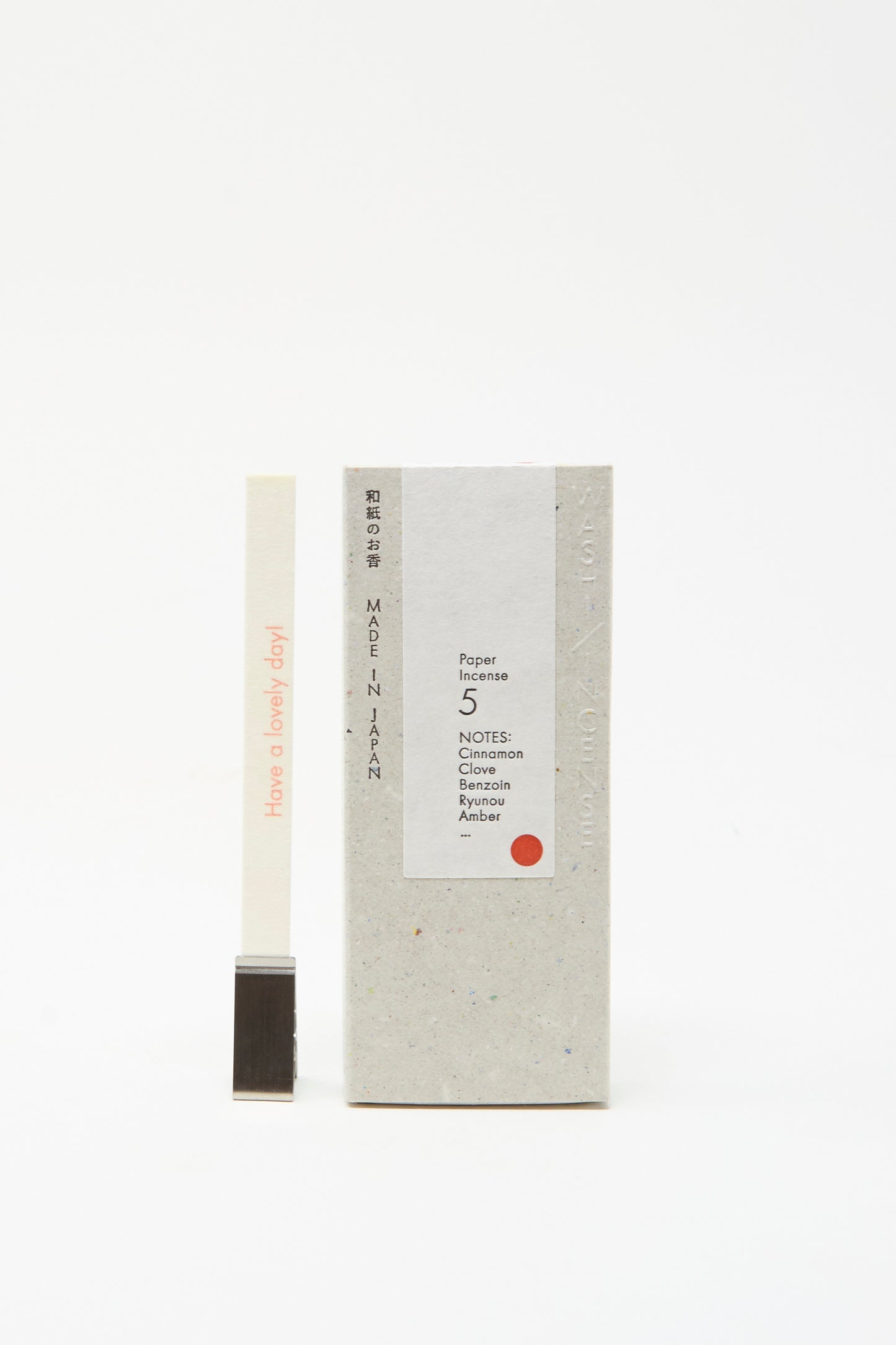 A box of Morihata Washi Paper Incense Strips in Smoky Comfort stands beside a natural aroma strip reading "Have a lovely day!"—held upright by a metal holder; crafted and made in Japan.