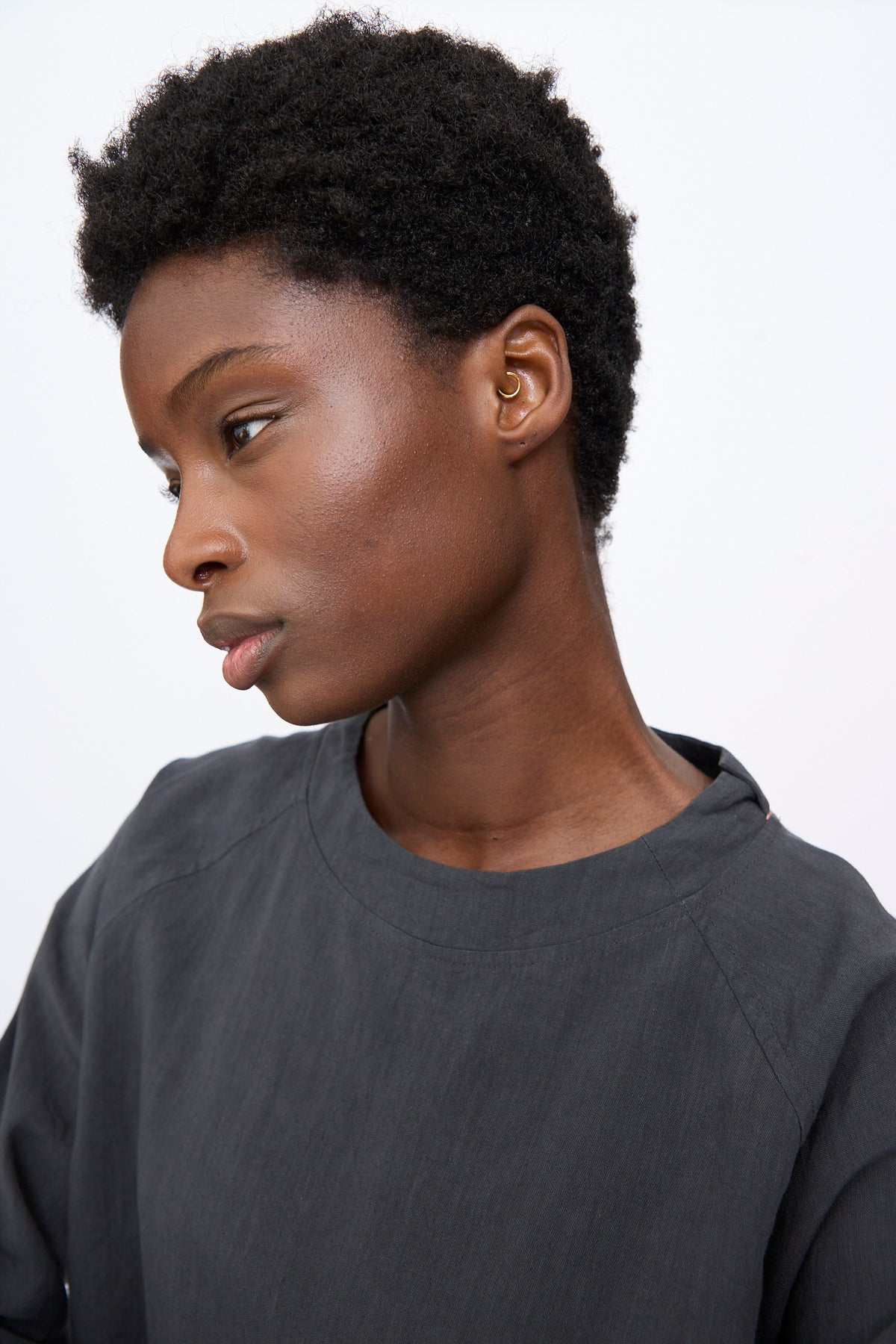 A person wearing a charcoal gray linen-blend Hallelujah Chemise de Berger in Gray with long raglan sleeves.