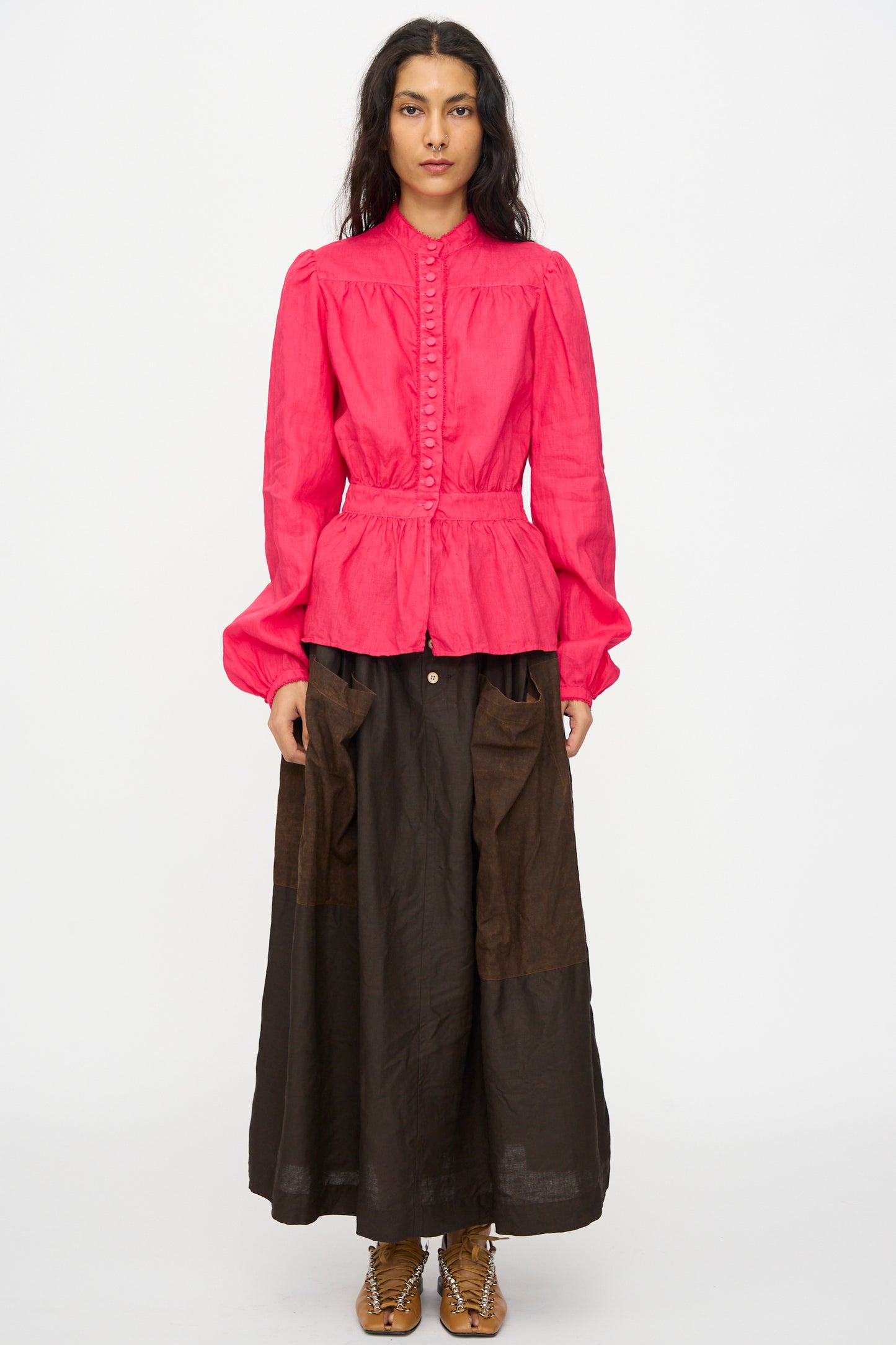 A person faces forward wearing the Hallelujah Linen Réplique de Chemise Victorienne in Cherry Red, a Japanese-made long sleeve blouse with buttons, paired with a brown ankle-length skirt and brown shoes, against a plain white background.