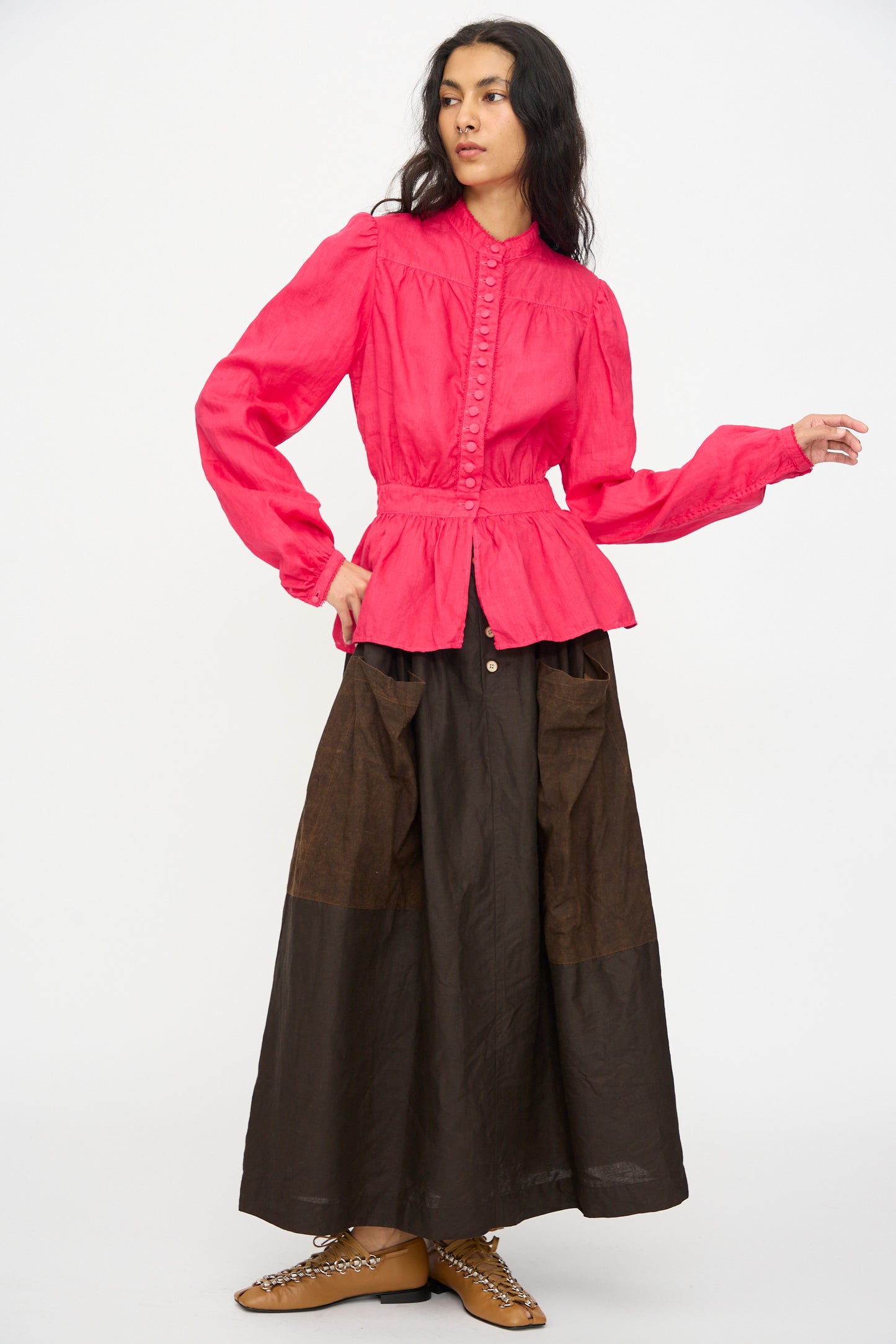 A person wearing the Hallelujah Linen Réplique de Chemise Victorienne in Cherry Red and a brown maxi skirt, standing against a plain white background.