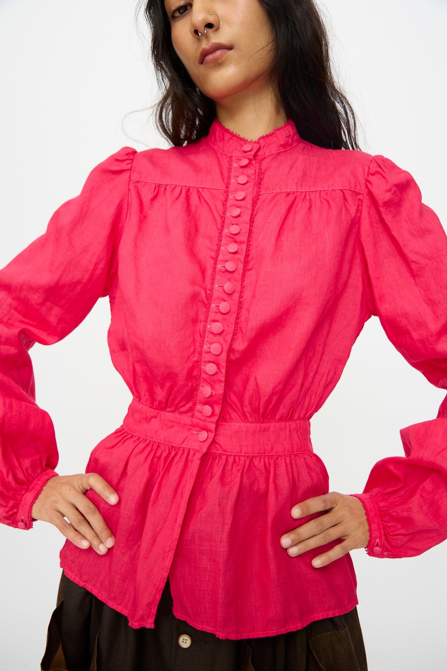 A person wears the Hallelujah Linen Réplique de Chemise Victorienne in Cherry Red, a long sleeve blouse with fabric-covered buttons, high collar, and gathered waist and shoulders—expertly crafted in Japan for standout style.
