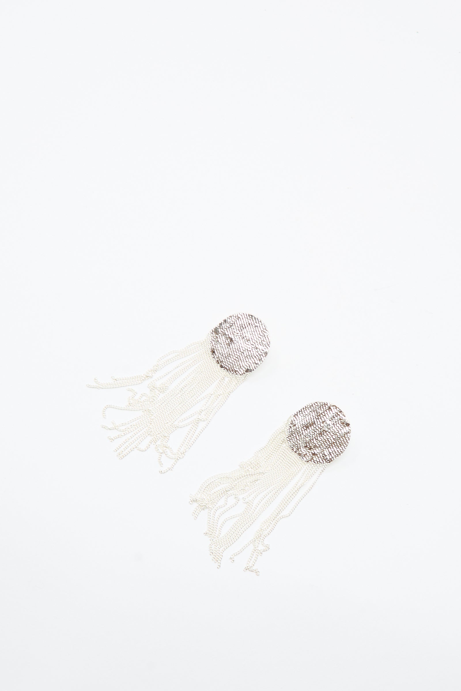 The Dot Earrings in Silver by Hannah Keefe are handmade and feature a circle design with dangling chain fringe, shown on a plain white background.