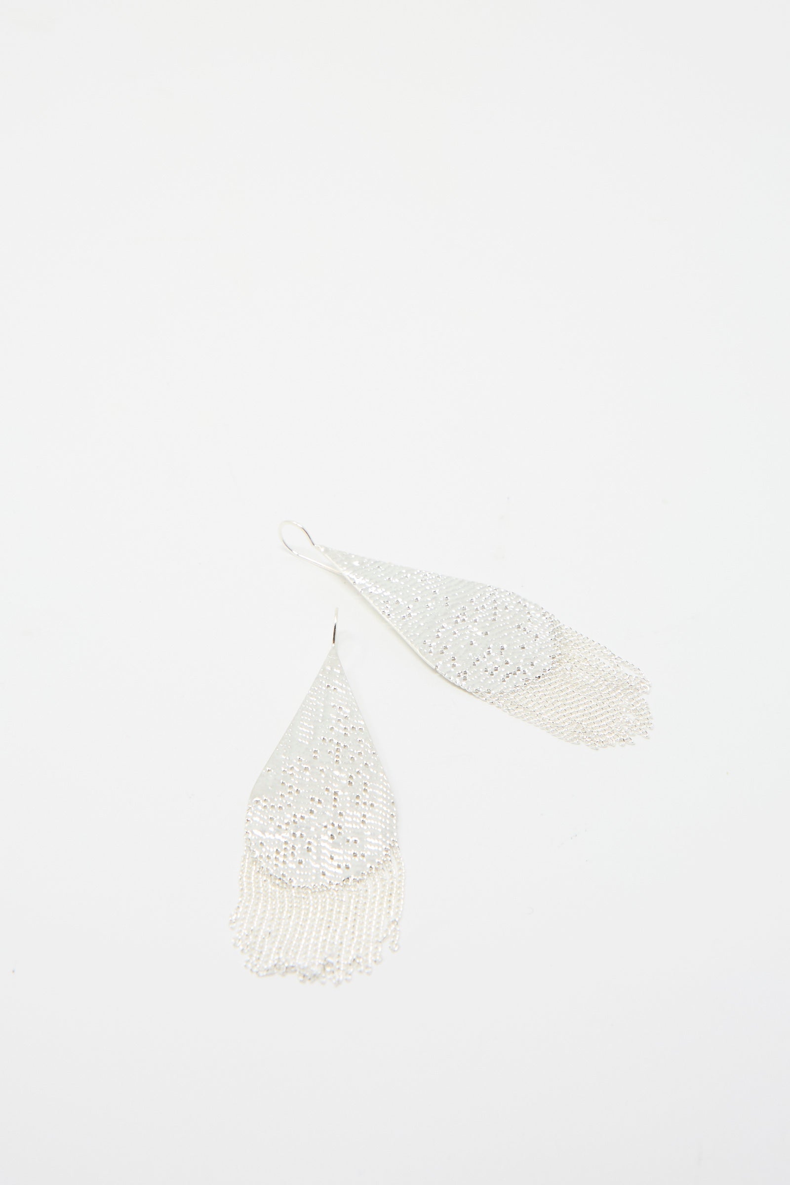 The Drip Earrings in Silver by Hannah Keefe are handmade in California, featuring a teardrop shape with silver chain fringe details on a white background.