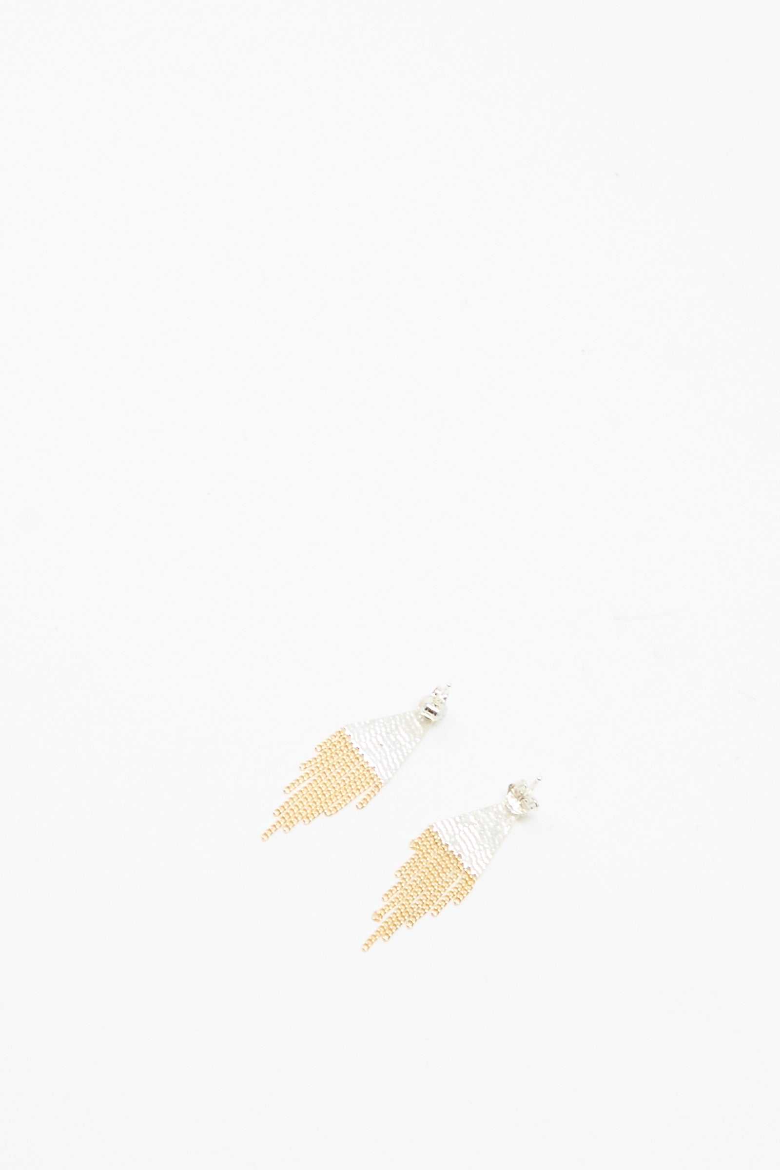 The Hannah Keefe Lil Triangle Studs in Brass and Silver are displayed on a plain white background. These handmade, earrings feature brass and silver beads with a unique triangular design.