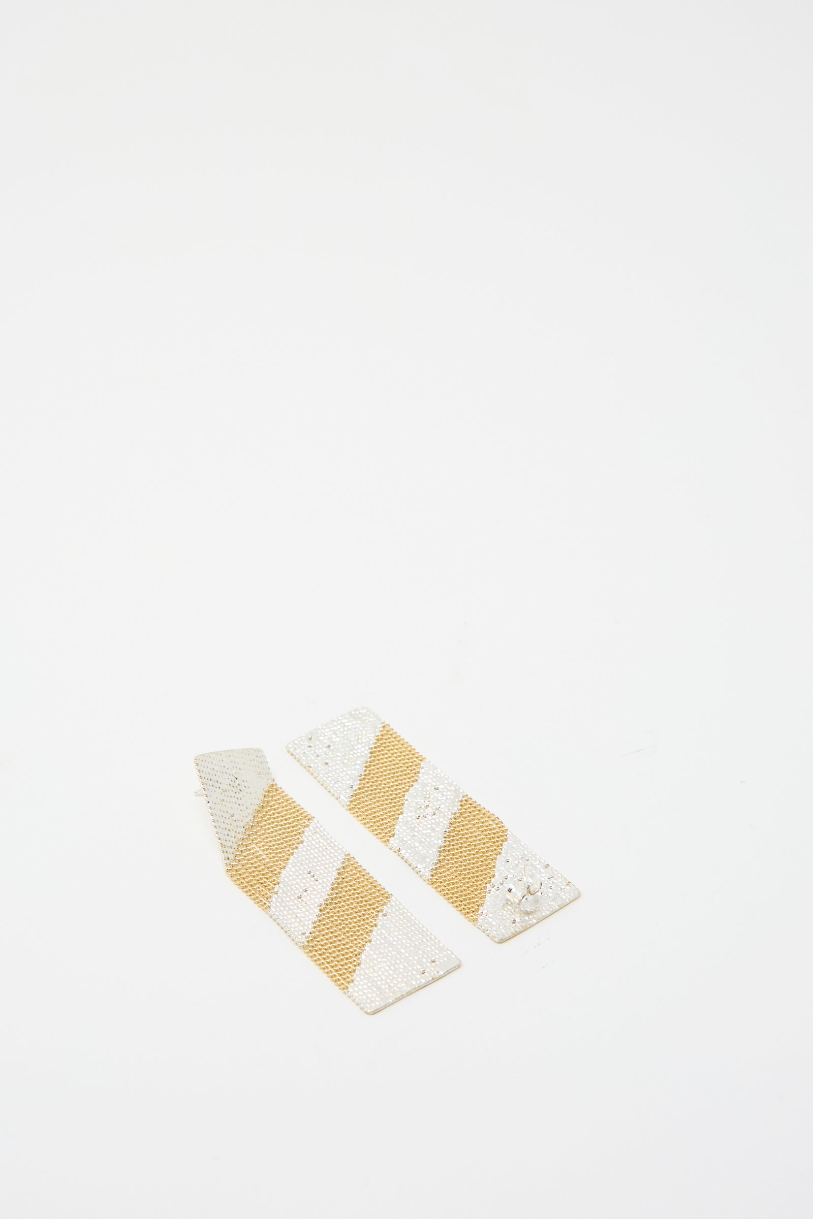 Two Sunny Earrings by Hannah Keefe, made with brass chain and silver solder stripes set against a white backdrop.