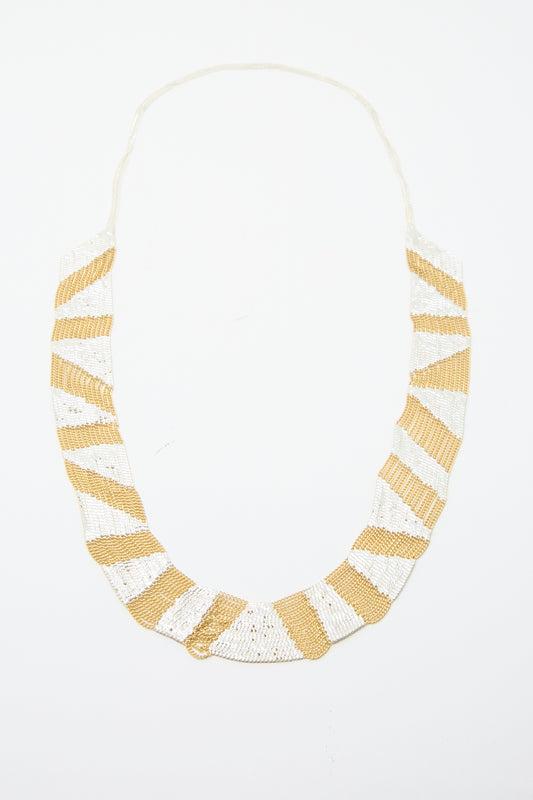 The Sunny Necklace in Brass and Silver by Hannah Keefe is showcased on a plain white background, featuring a geometric pattern with brass and silver soldered chains. 