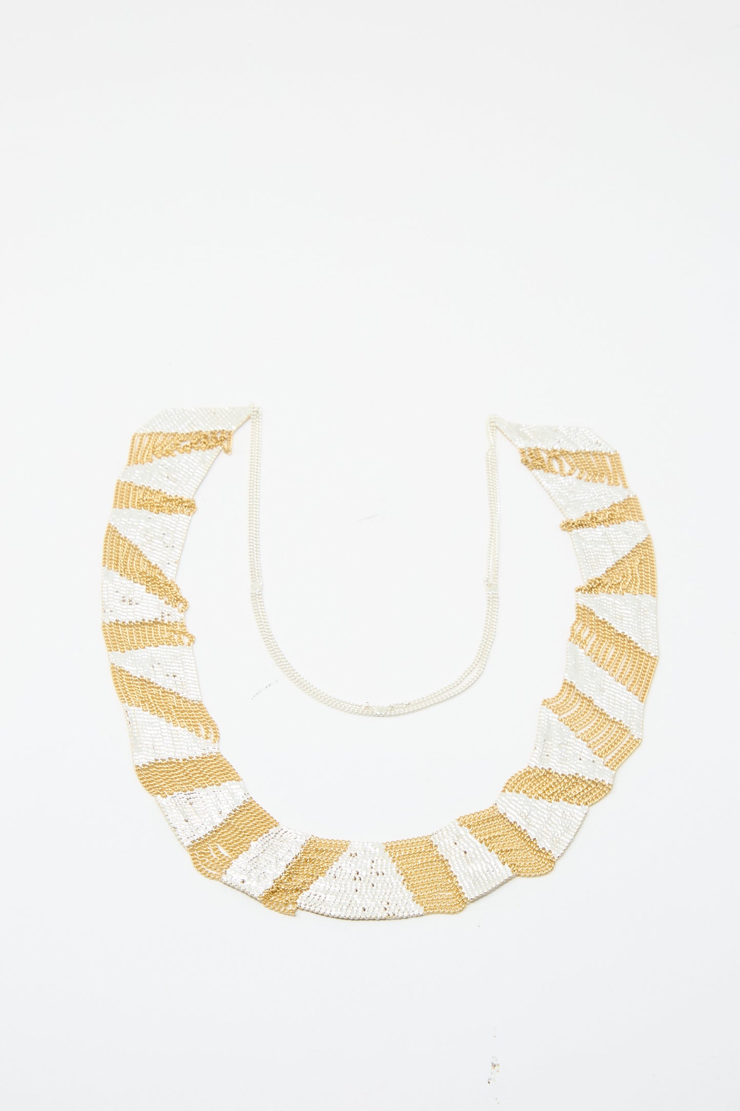 The Sunny Necklace in Brass and Silver by Hannah Keefe showcases alternating brass and silver stripes set against a white backdrop.