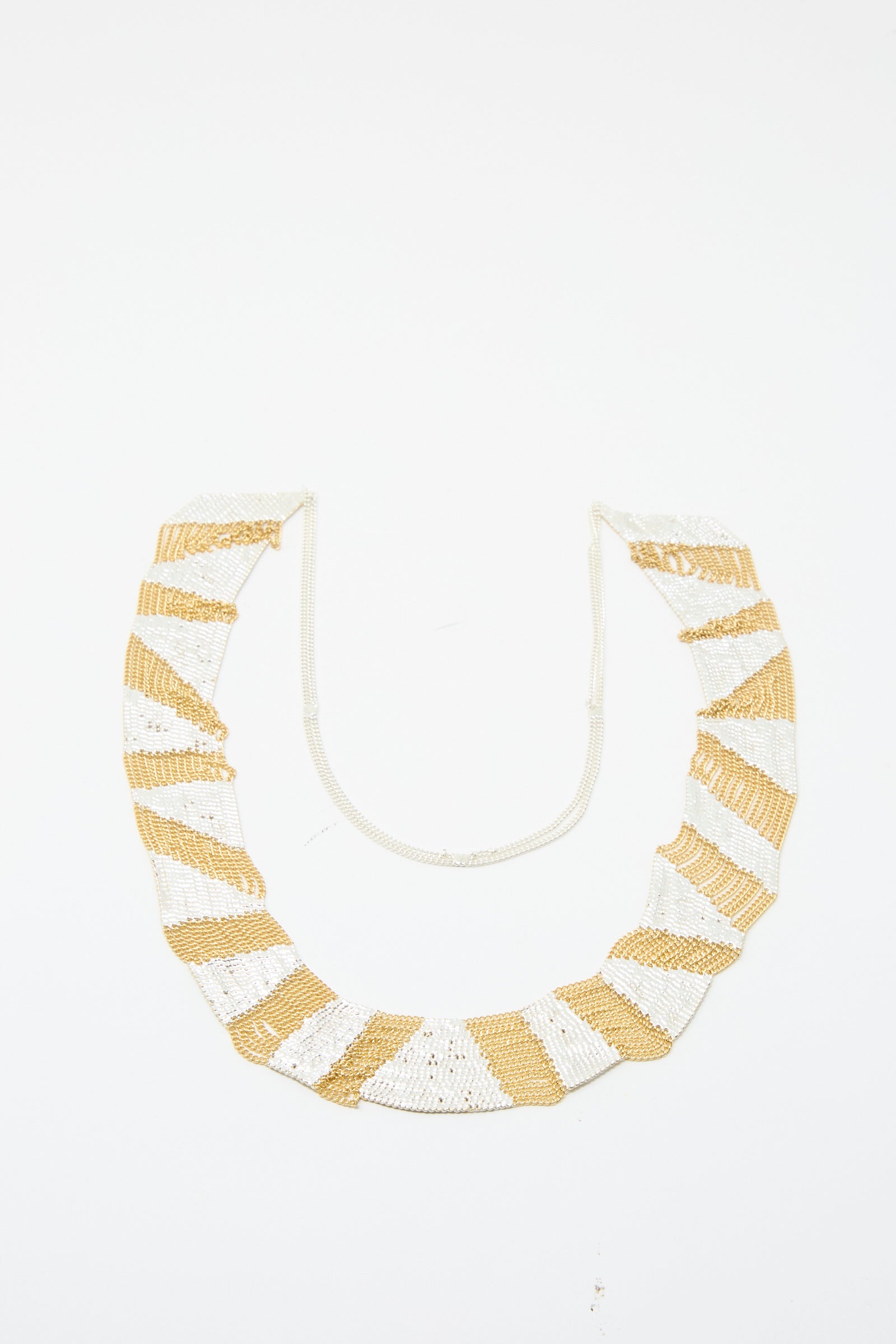 The Sunny Necklace in Brass and Silver by Hannah Keefe showcases alternating brass and silver stripes set against a white backdrop.