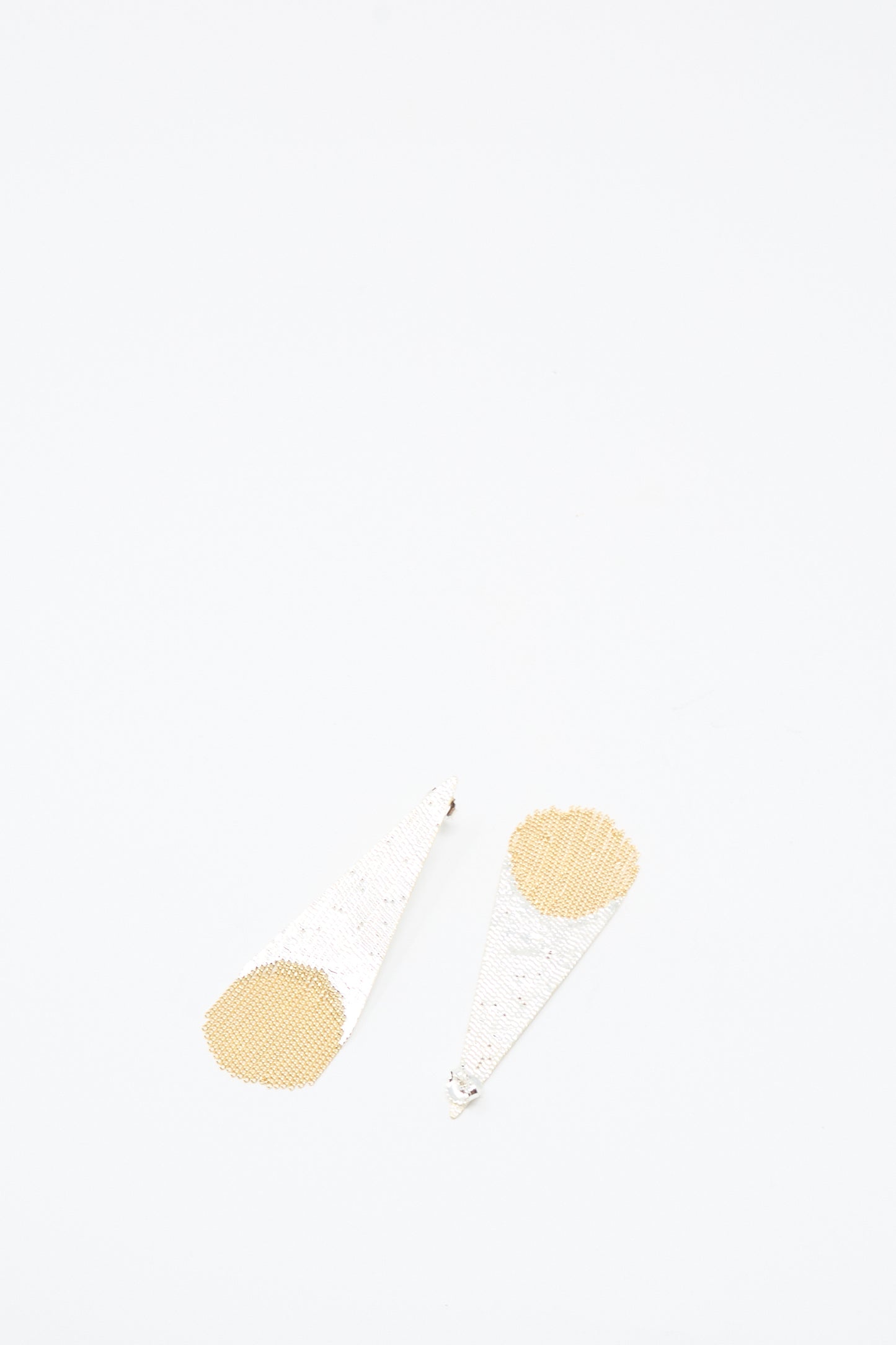 Hannah Keefe Teardrop Earrings in Brass and Silver, featuring cone-shaped white textured bodies and circular gold-toned bases, handmade in California, are shown on a plain white background.