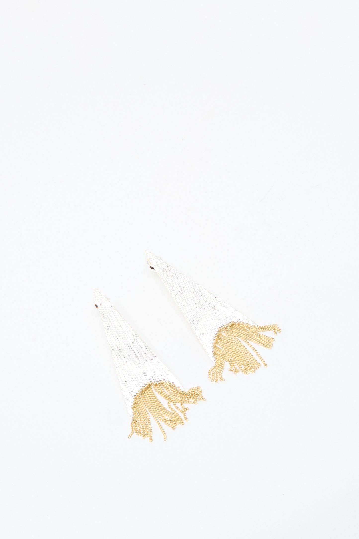 The Teardrop Earrings in Brass and Silver by Hannah Keefe feature a white, triangular design with silver brass fringe, handmade in California and shown on a plain white background.