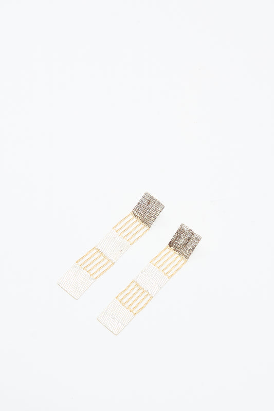 The Train Earrings in Brass and Silver by Hannah Keefe are rectangular drop earrings with alternating gold and silver striped segments, shown on a white background.