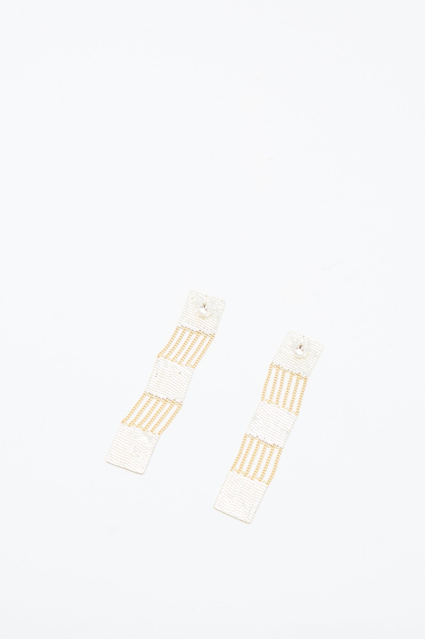 The Train Earrings in Brass and Silver by Hannah Keefe, handmade in Los Angeles, are rectangular earrings with a white and gold finish, shown on a plain white background.