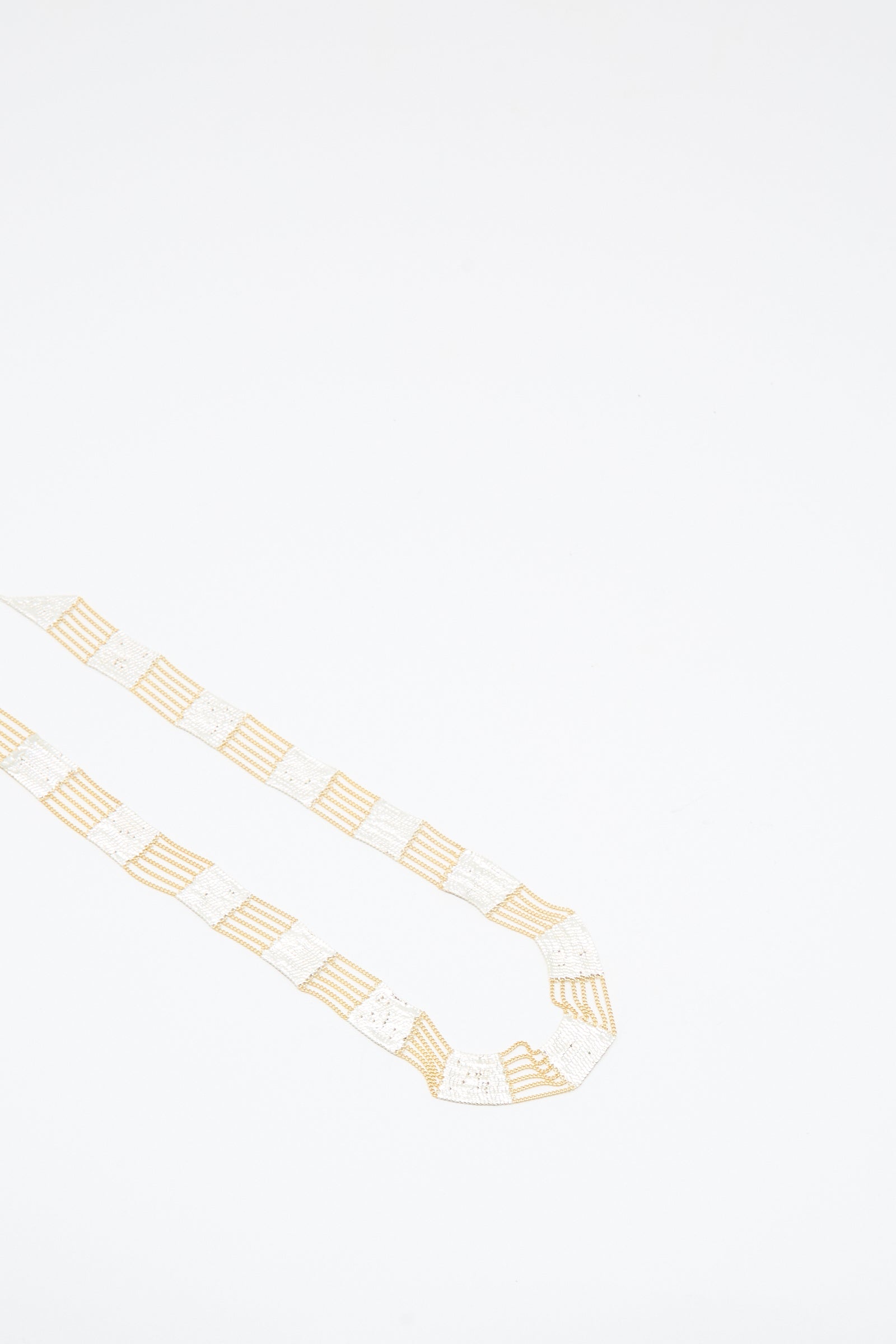 The Train Necklace in Brass and Silver by Hannah Keefe is displayed on a plain white background, showcasing the unique artistry of Los Angeles jewelry.