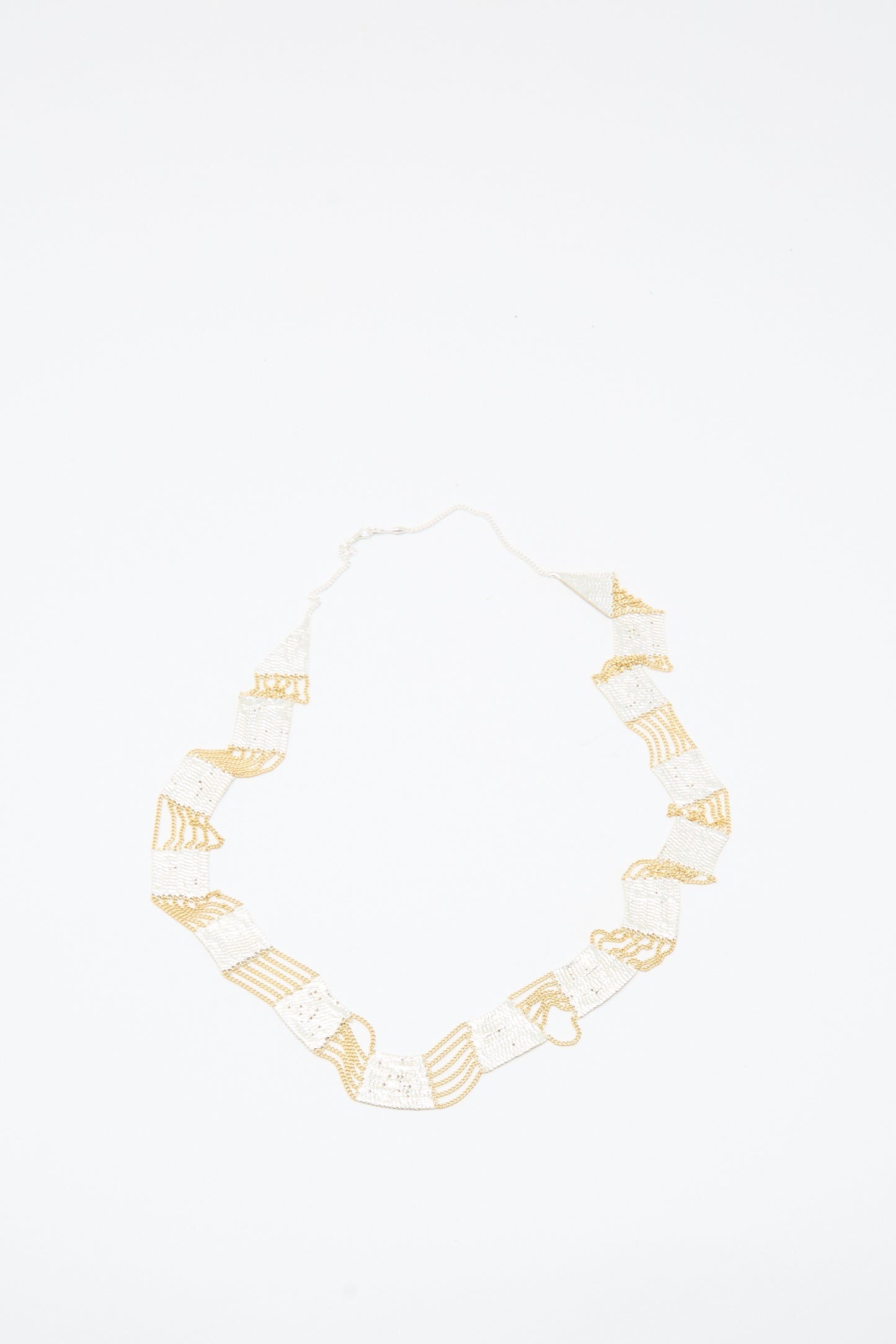 Train Necklace in Brass and Silver by Hannah Keefe, featuring a geometric handmade design, is displayed on a white background.
