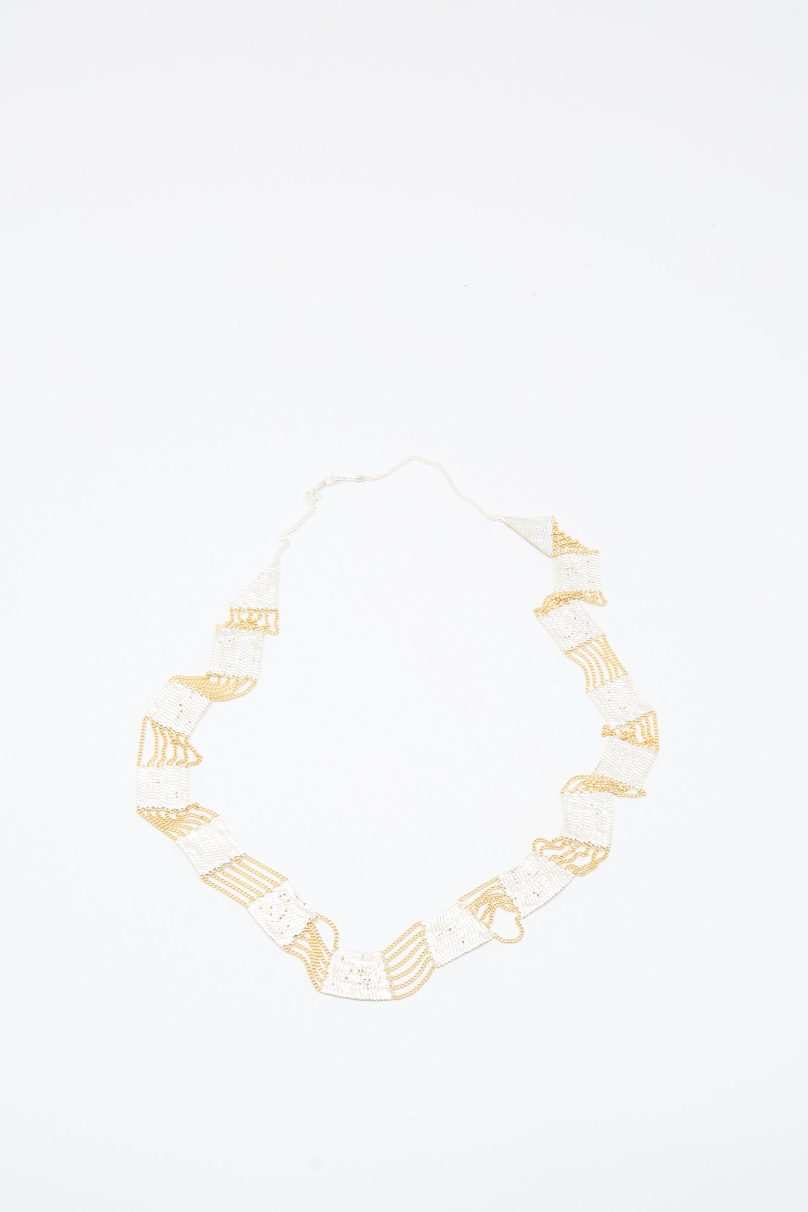Train Necklace in Brass and Silver by Hannah Keefe, featuring a geometric handmade design, is displayed on a white background.