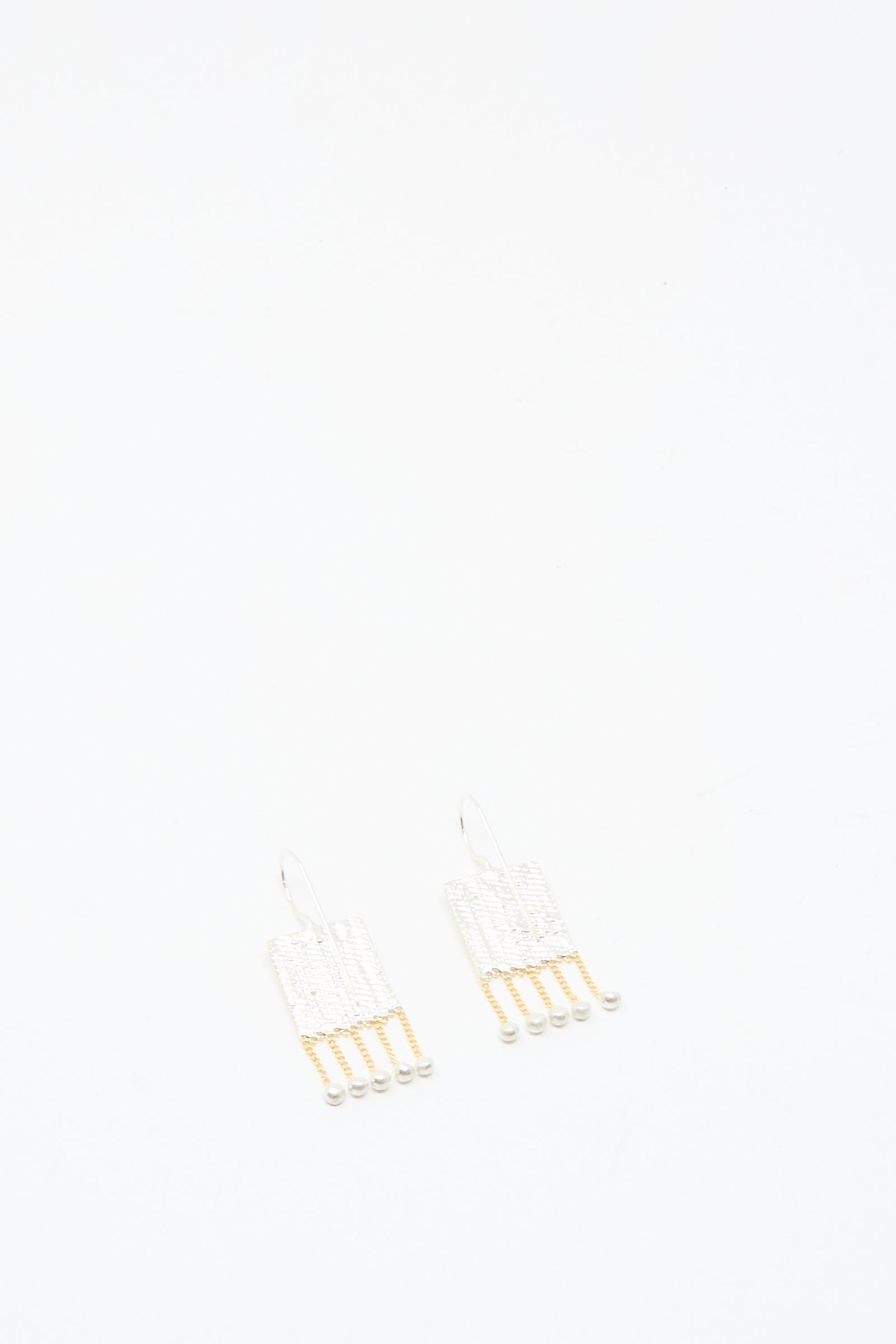 Bauble Earrings in Brass and Silver by Hannah Keefe showcase handmade elegance with white and gold beads on delicate brass chains, set against a plain white background.