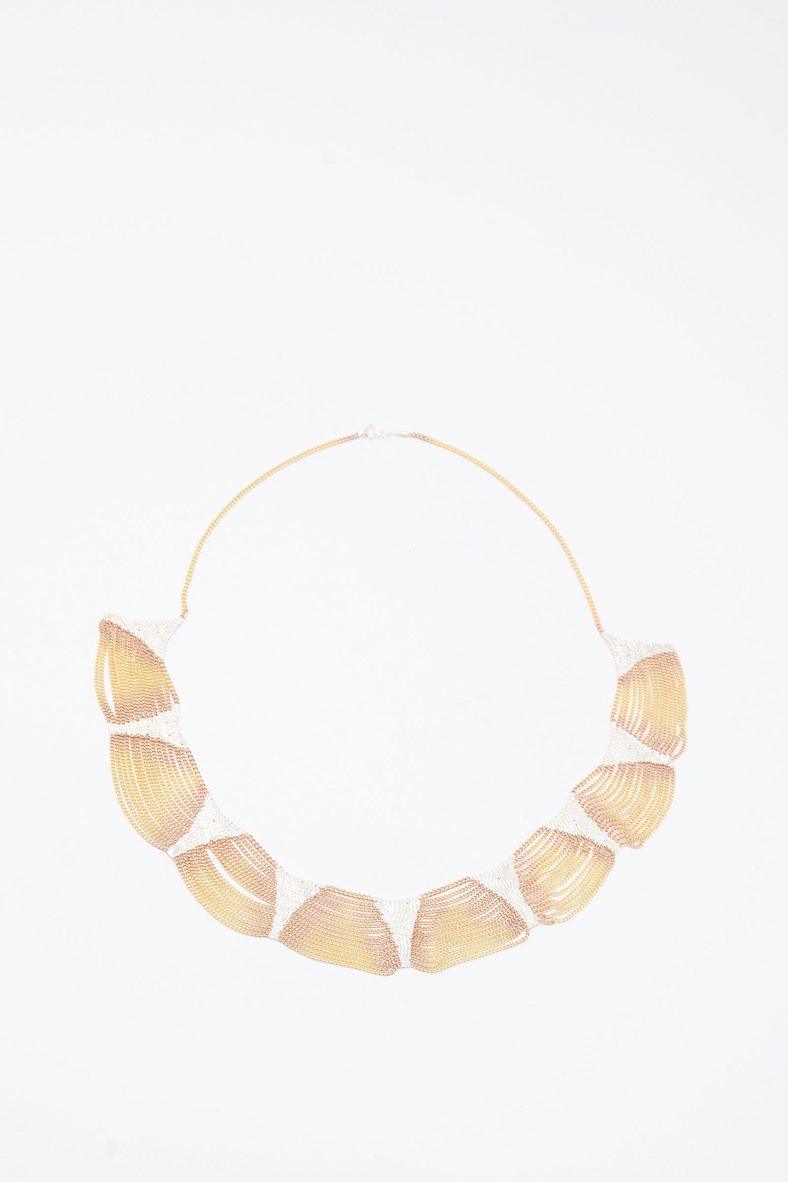 The Deanna Necklace in Brass and Silver by Hannah Keefe features large shell-shaped segments on a thin chain, handmade in California, and is shown on a white background.