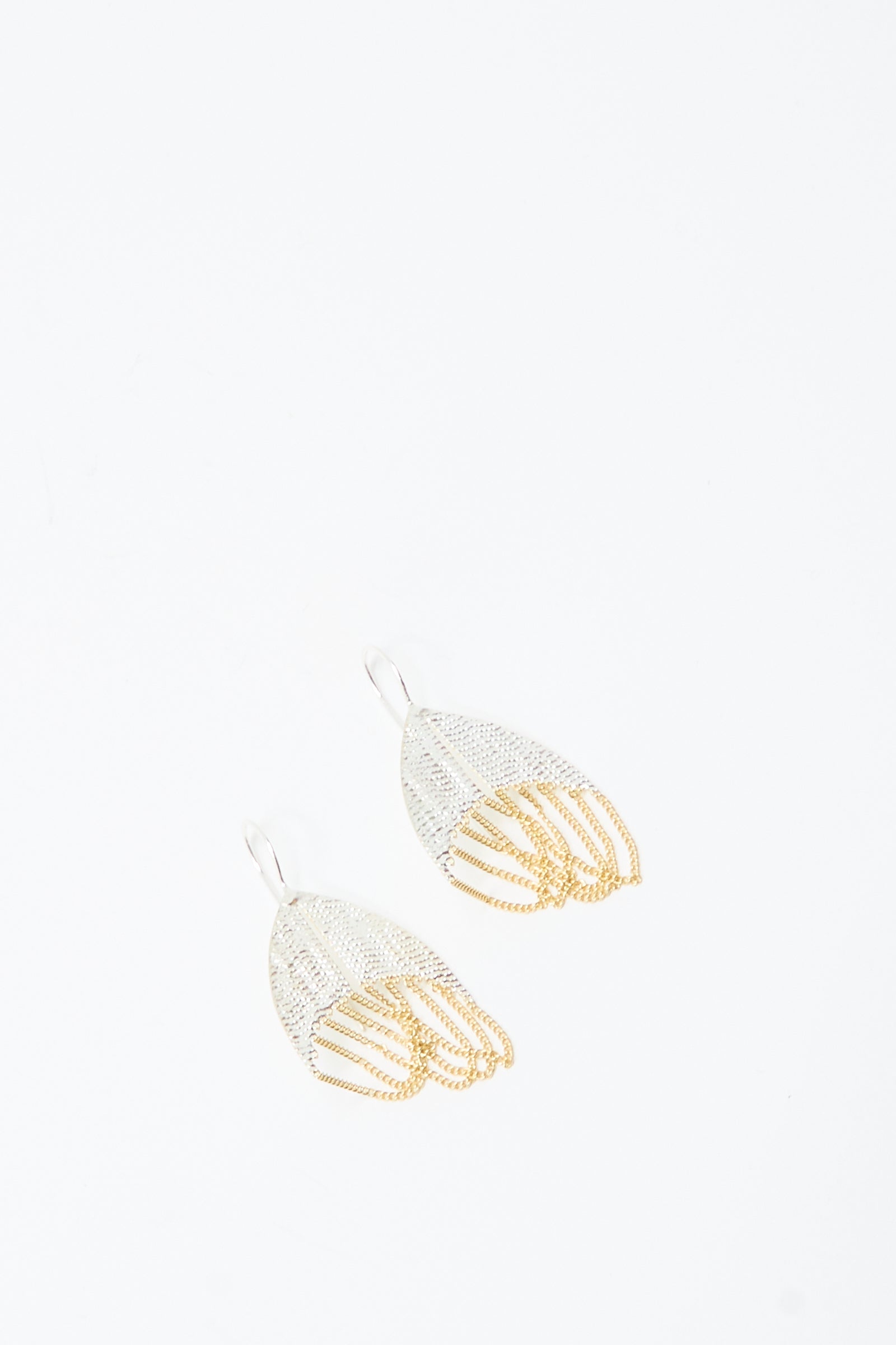 The Scarab Earrings in Brass and Silver by Hannah Keefe are handmade hook earrings with a silver upper and gold lower mesh-like, layered design, shown on a plain white background.