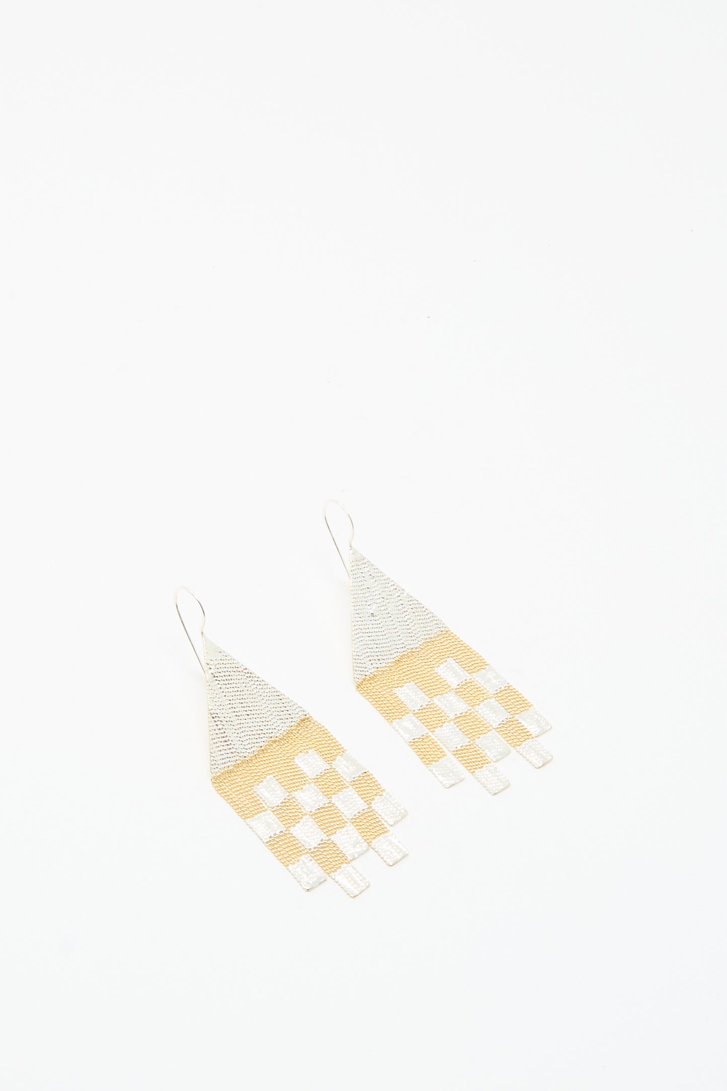 The Hannah Keefe Scotch Earrings in Brass and Silver are handmade in California, featuring geometric design with triangular tops and rectangular fringes in a silver and gold checkered pattern.