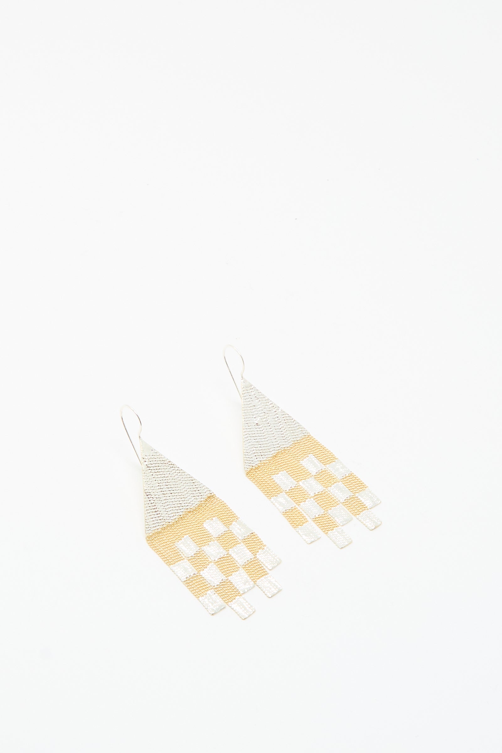 The Hannah Keefe Scotch Earrings in Brass and Silver are handmade in California, featuring geometric design with triangular tops and rectangular fringes in a silver and gold checkered pattern.