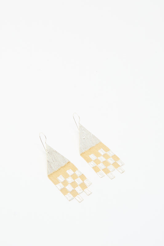 The Hannah Keefe Scotch Earrings in Brass and Silver are handmade in California, featuring geometric design with triangular tops and rectangular fringes in a silver and gold checkered pattern.