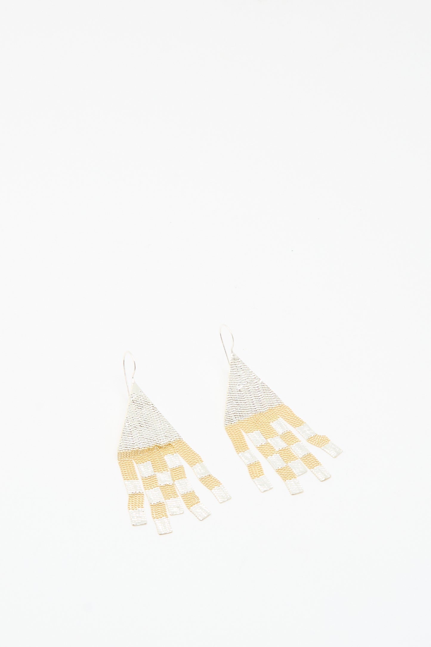 The Scotch Earrings in Brass and Silver by Hannah Keefe are handmade in California, featuring brass and silver checkerboard triangles with dangling rectangular fringe.