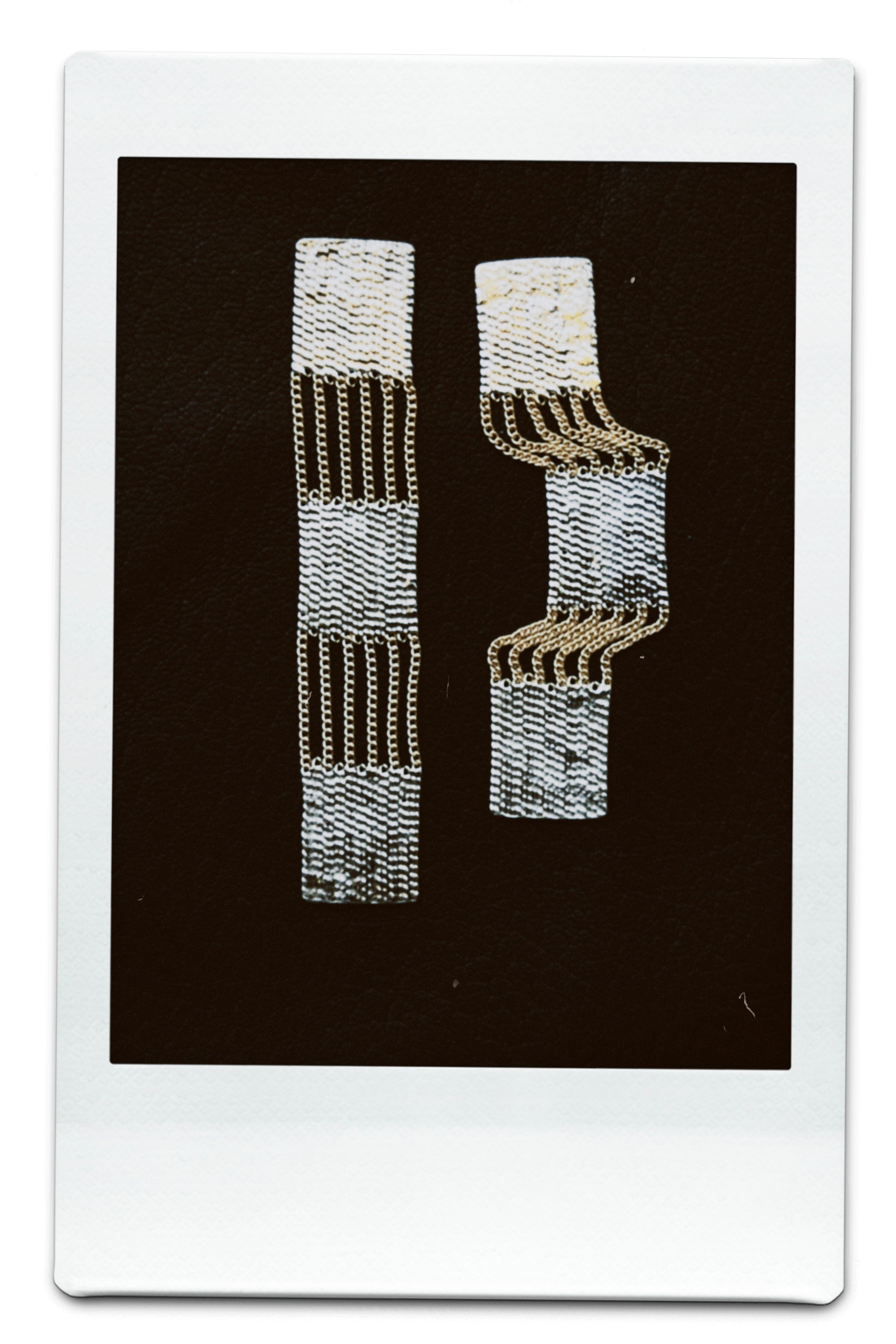 A polaroid of Hannah Keefe's Train Earrings in Brass and Silver.