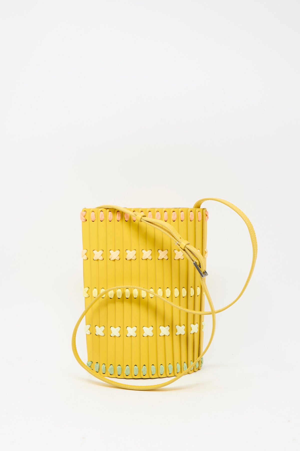 Yellow cylindrical Hatori Leather Crossbody 30 Artist Edition with Holly Coulis in Yellow, featuring a slim shoulder strap and decorative woven details in pastel colors.