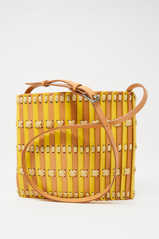The Hatori Leather Crossbody 48 in Natural and Yellow with Ecru Lace features a square shape, vertical strips, cream woven details, and a tan adjustable strap, all expertly handcrafted and displayed on a plain white background.