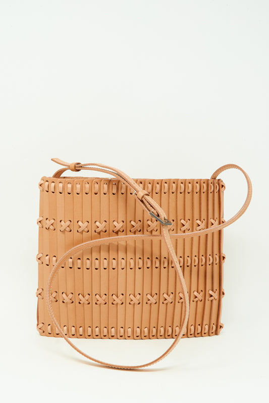The Hatori Leather Crossbody 48 in Natural with Tanned Lace features a square design, woven stitched pattern, and long thin shoulder strap, handcrafted from vegetable tanned leather and shown against a plain white background.