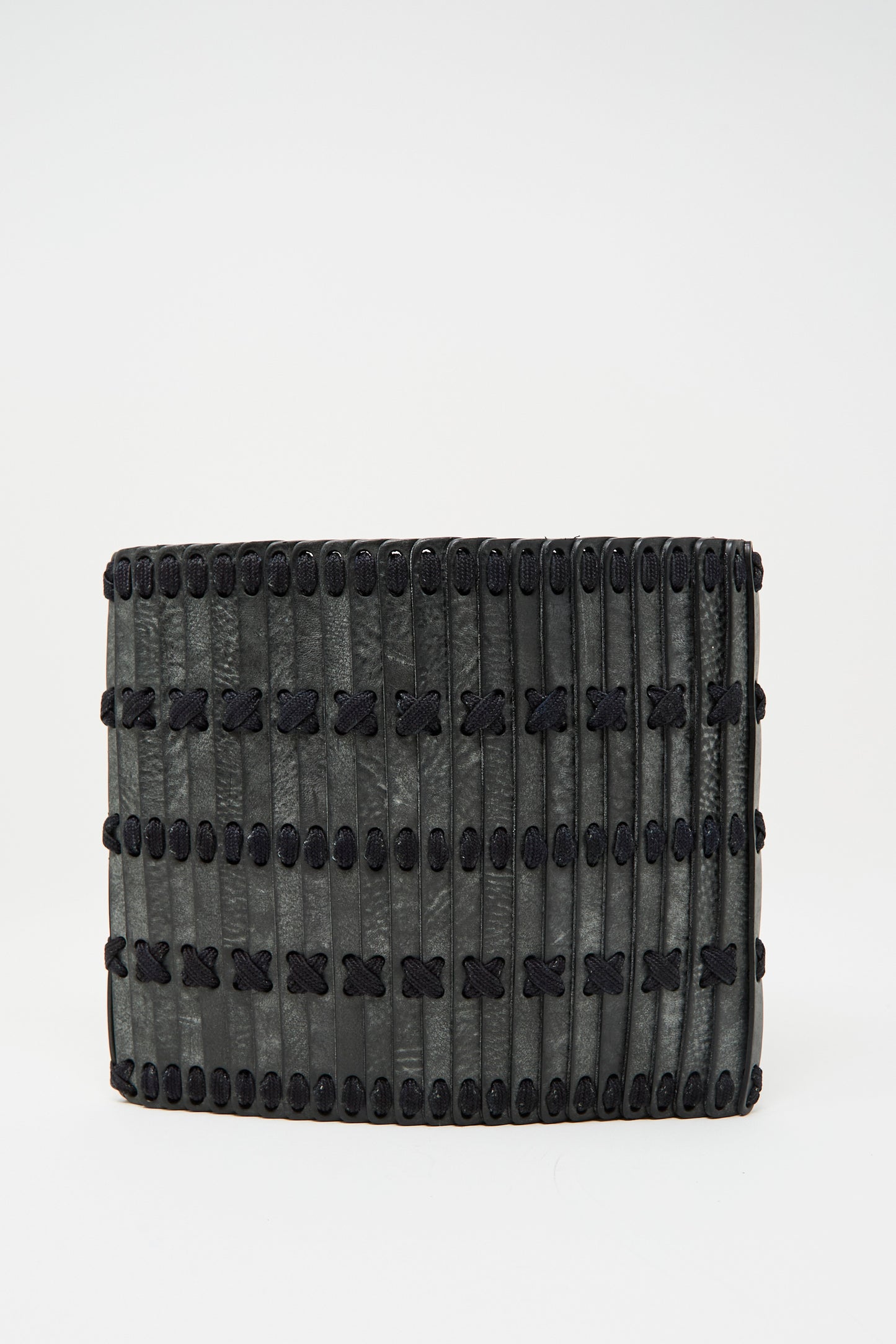 The Hatori Leather Crossbody 48 Bag in Waxed Coated Black with Indigo Lace features a textured, ribbed surface and black crisscross stitching, shown against a plain white background.