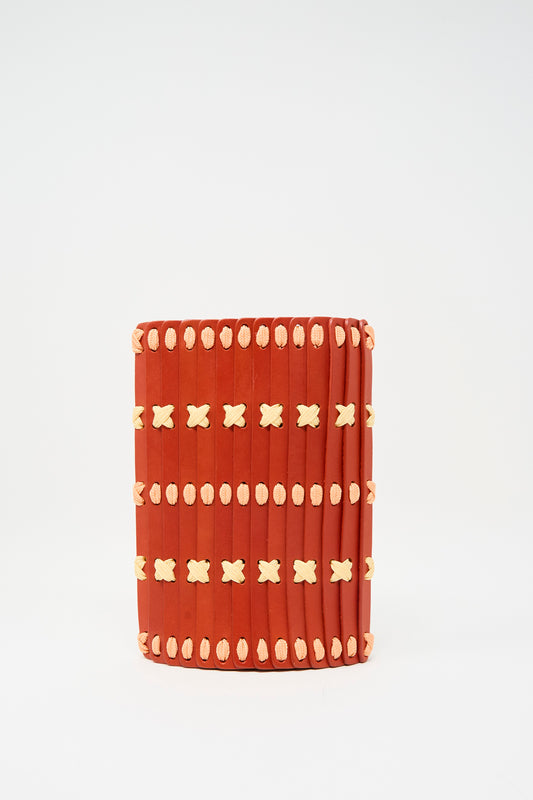 The Hatori Leather Phone 26 Bag in Tomato features vertical slats and two rows of lemon and pink X-shaped stitches on the front, shown against a plain white background.