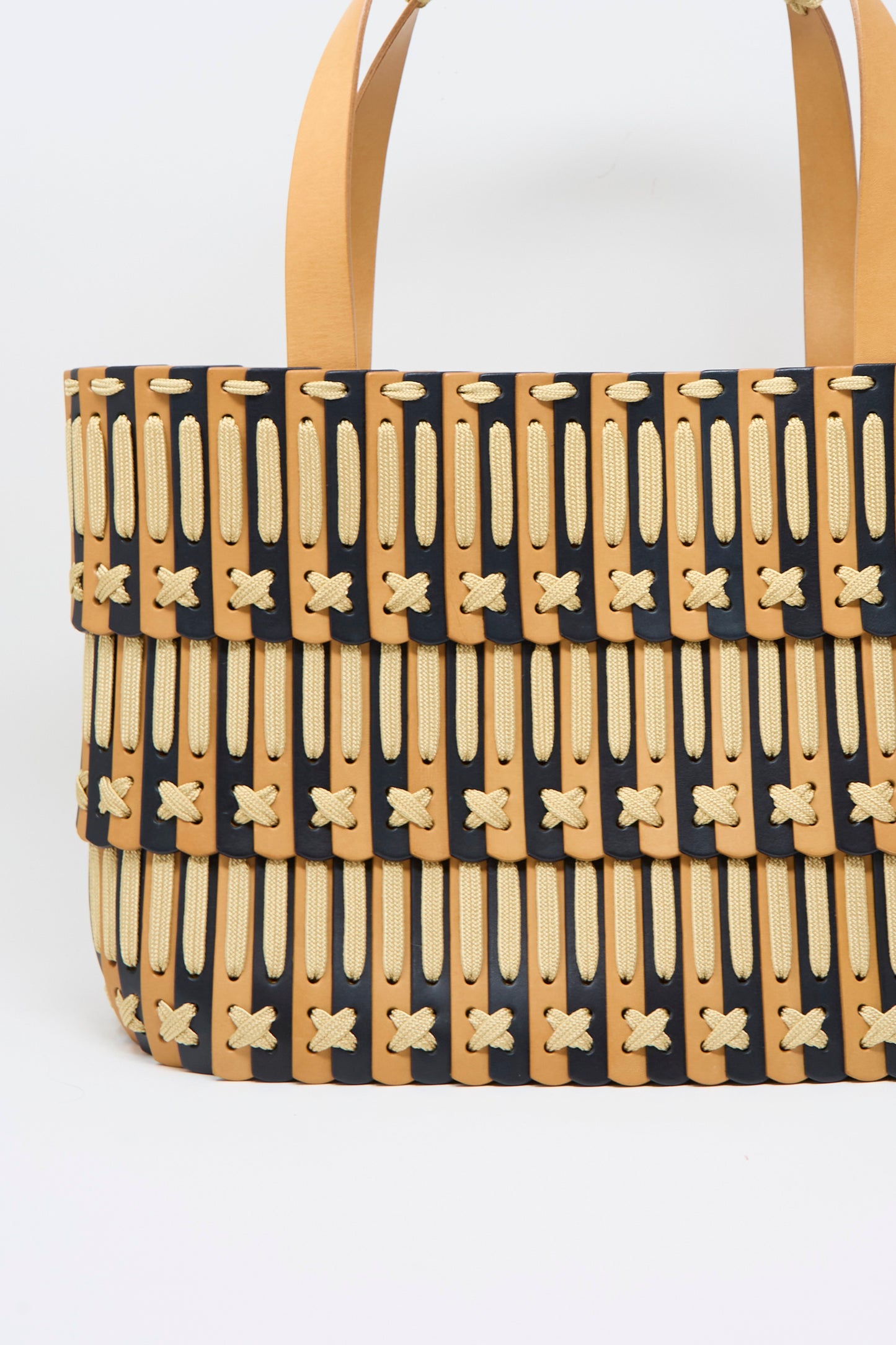 Hatori Leather Tote 198 in Bi-Color with Tan Lacing, featuring tan, black, and cream woven leather, distinctive crisscross stitching, and two tan handles; expertly handcrafted in Tokyo and pictured against a plain white background.