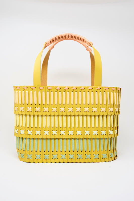 Hatori Leather Tote 198 Artist Edition with Holly Coulis in Yellow handcrafted leather featuring woven strips and decorative crisscross stitching in pale green, pink, and cream.