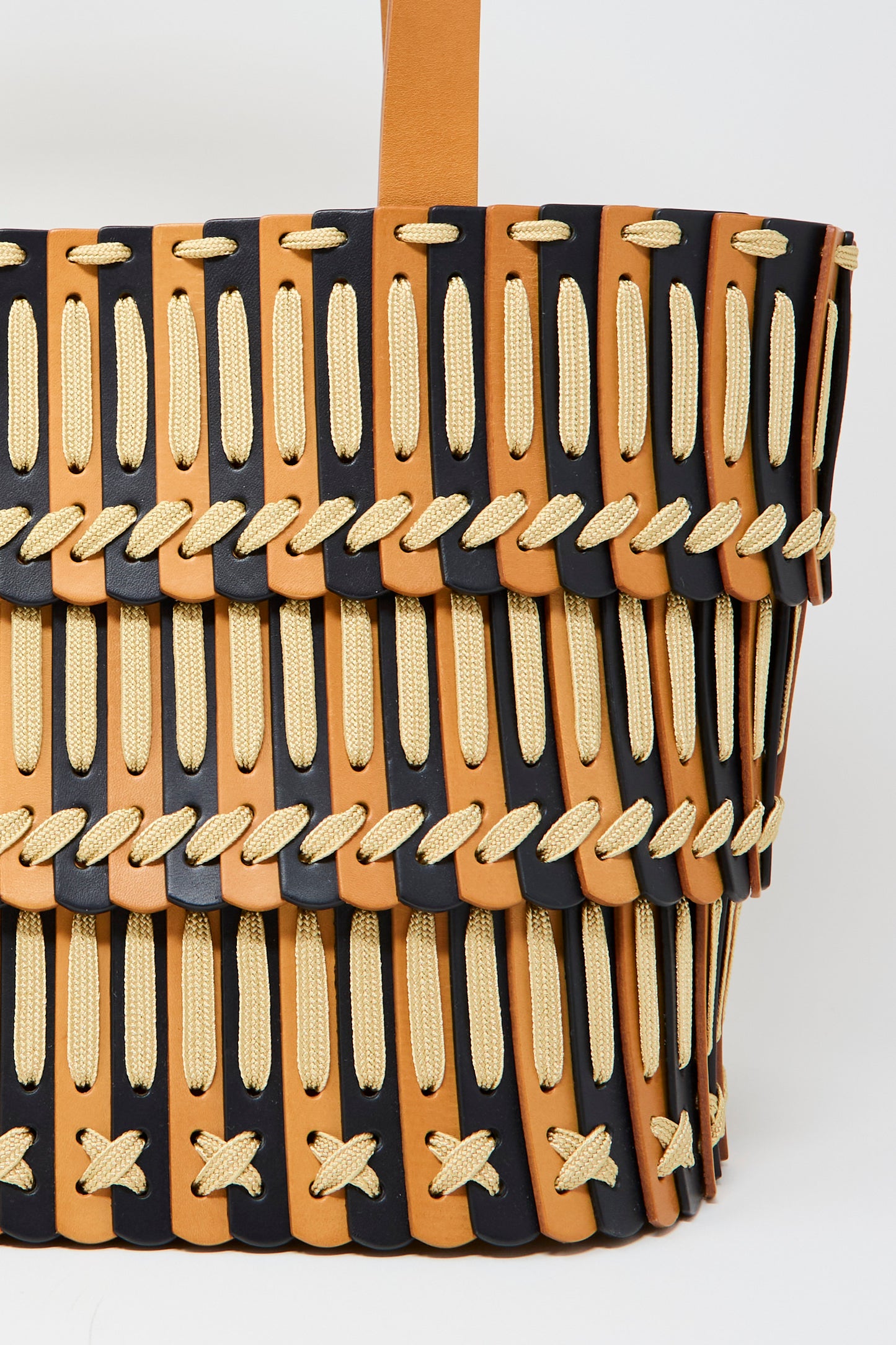 Close-up of the Hatori Leather Tote 198 Bag, handcrafted in natural and midnight blue leather with ecru lace crisscross lacing.