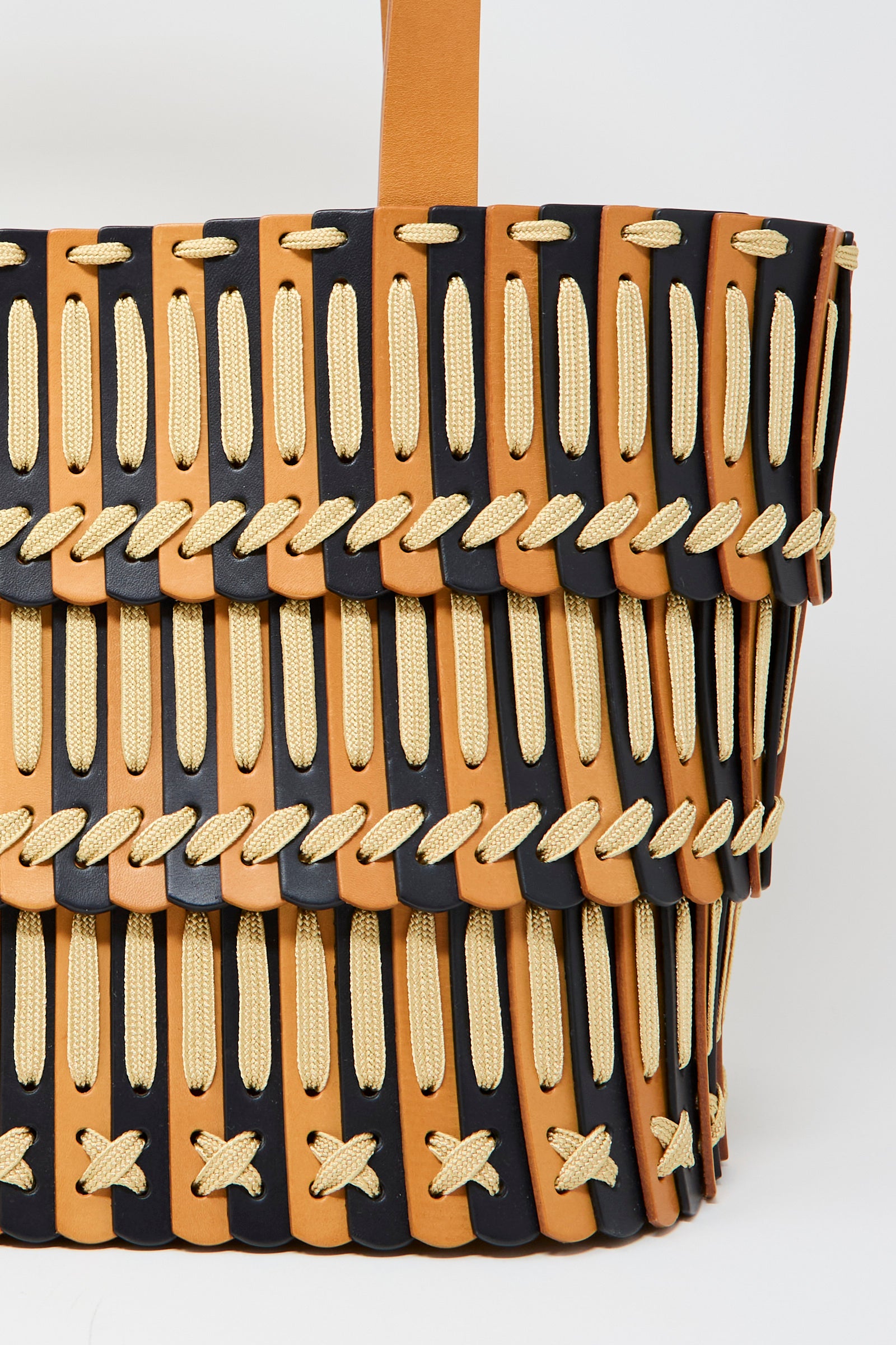 Close-up of the Hatori Leather Tote 198 Bag, handcrafted in natural and midnight blue leather with ecru lace crisscross lacing.