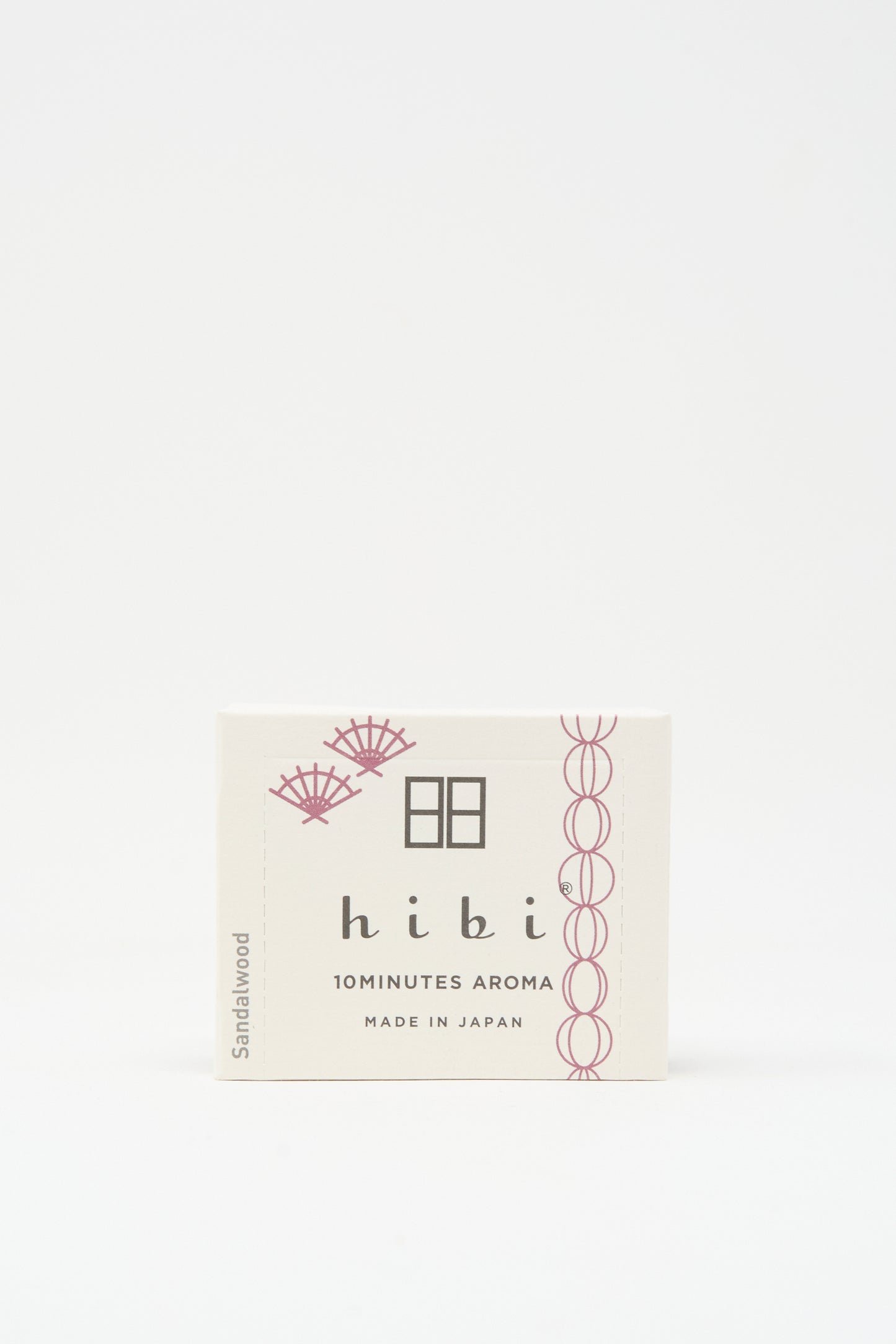 A white Hibi Incense Matches box labeled "10 MINUTES AROMA, MADE IN JAPAN" with a sandalwood scent and subtle pink accents, containing handcrafted Japanese matches.