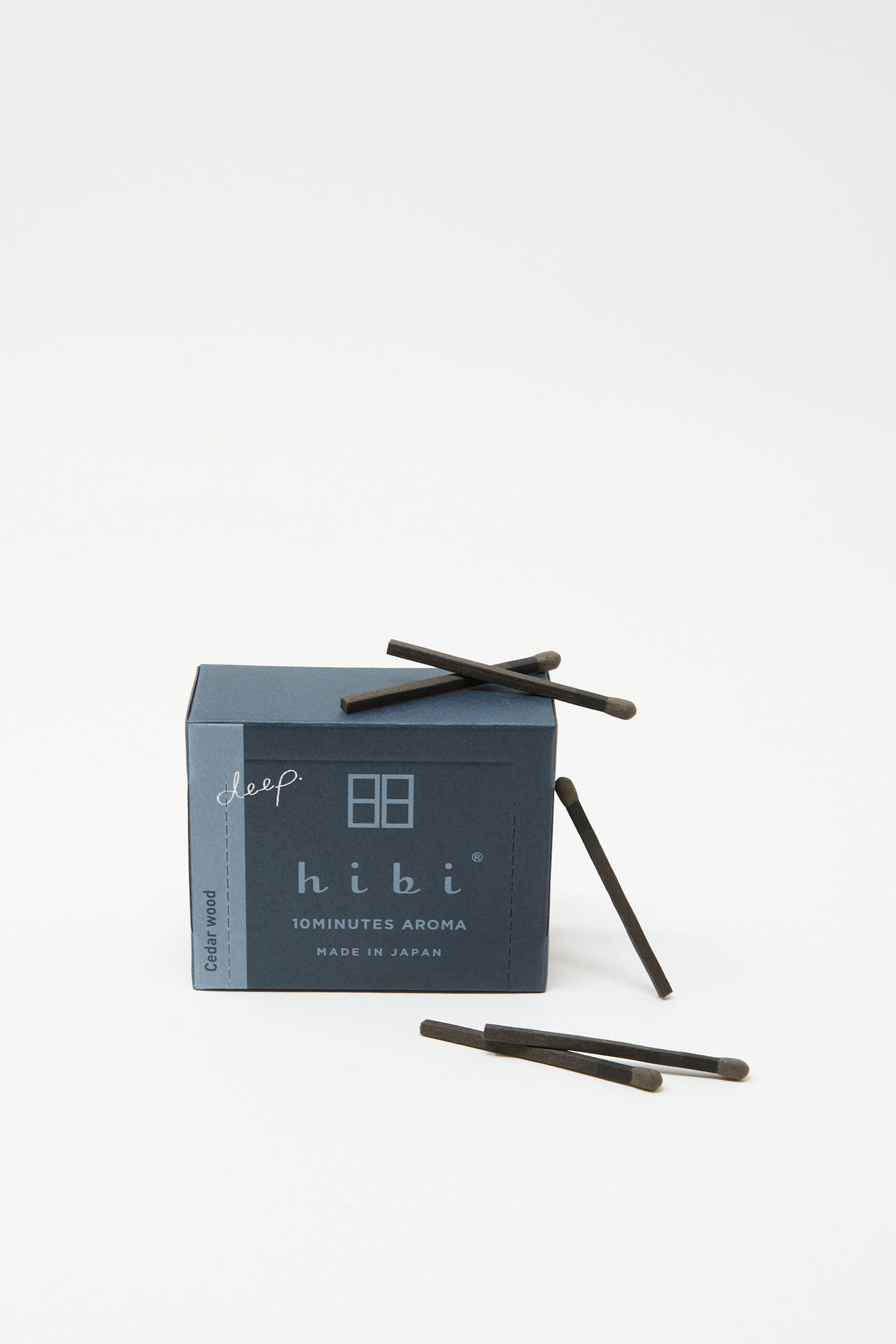 A blue box labeled "Hibi Cedarwood Incense Matches" with several black incense matches beside it, set against a white background.