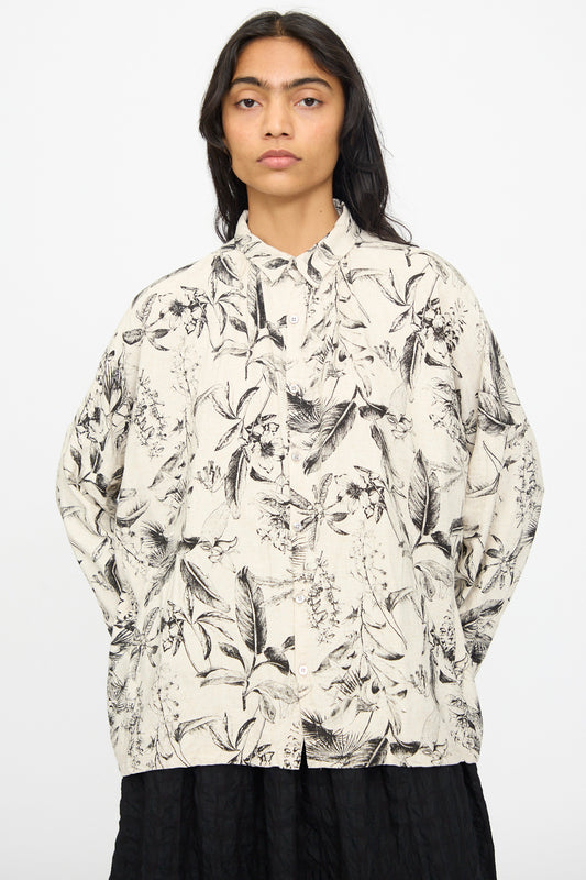 Model wears the Ichi Antiquités Botanical Print Shirt in Natural, featuring a relaxed fit and long sleeves with a black and beige botanical pattern, paired with a black skirt against a plain light background.