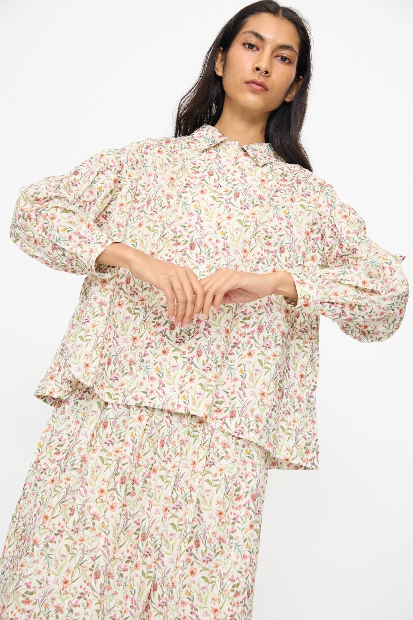 A woman wears the Ichi Antiquités Cotton Liberty Shirt in Flower Print, styled loosely with a matching skirt, set against a plain white background.