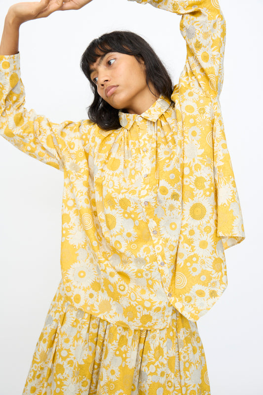 A woman in the Ichi Antiquités Cotton Liberty Shirt in Yellow poses with her arms raised against a plain white background.