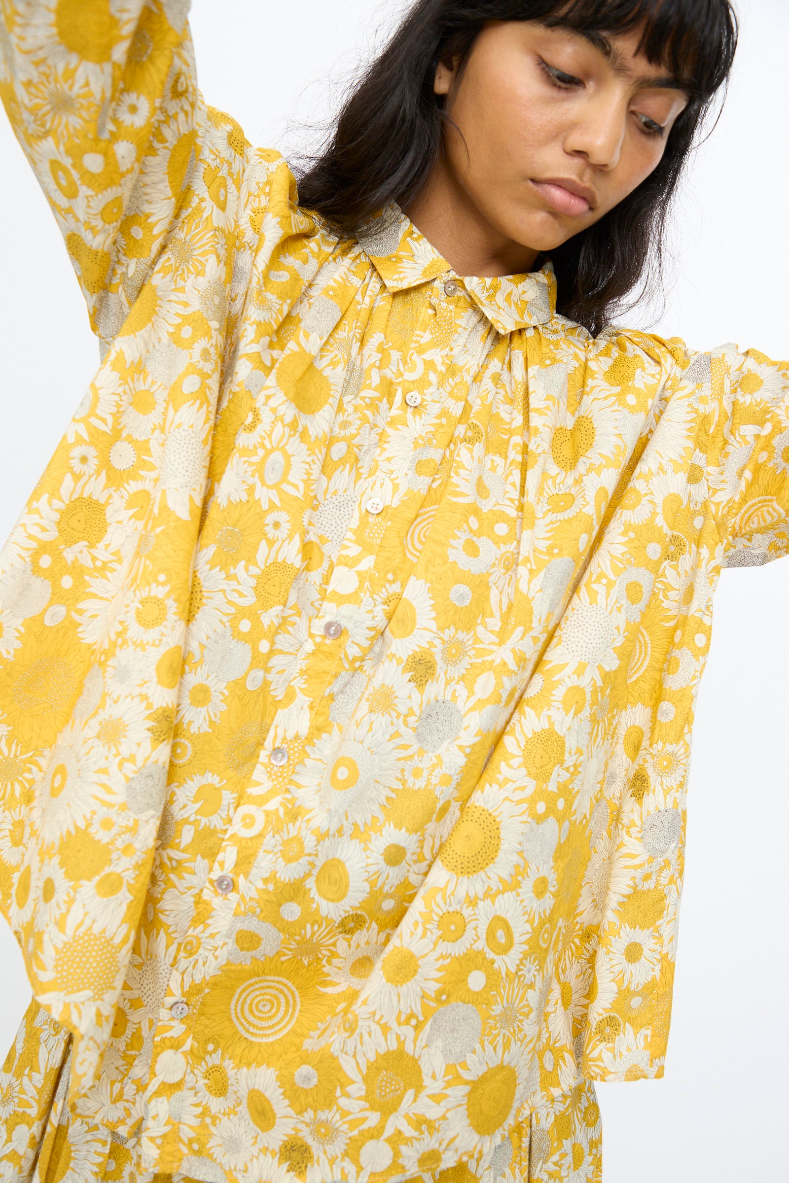 A person stands with arms raised against a plain background, wearing the Ichi Antiquités Cotton Liberty Shirt in Yellow.