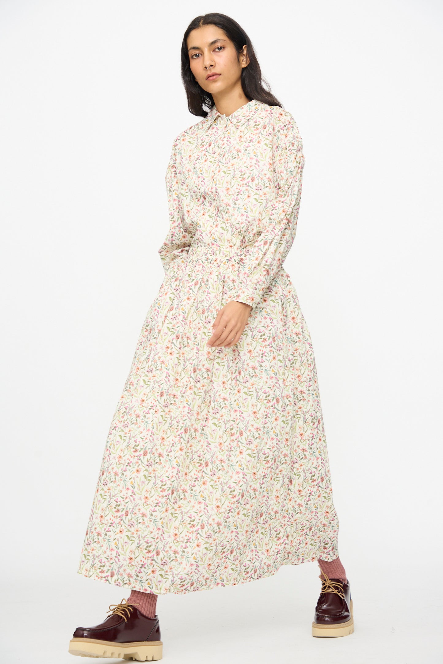 A person wearing the Ichi Antiquités Cotton Liberty Skirt in Flower Print with maroon shoes and pink socks stands against a plain white background.