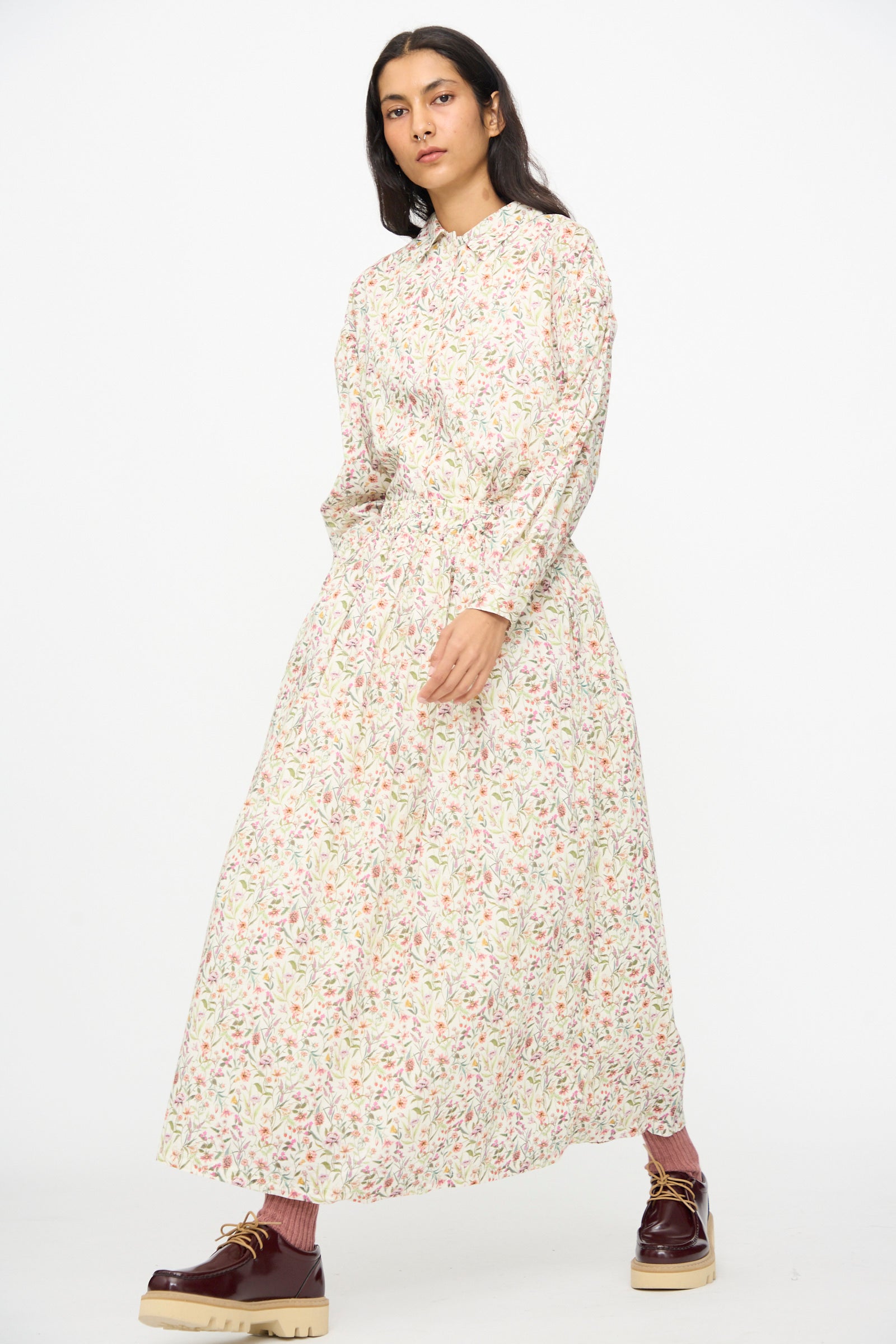 A person wearing the Ichi Antiquités Cotton Liberty Skirt in Flower Print with maroon shoes and pink socks stands against a plain white background.