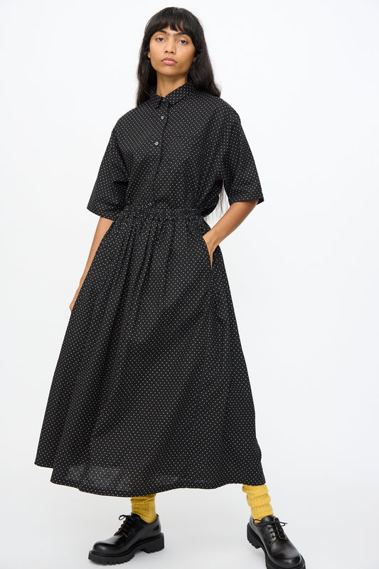 A woman stands against a plain white background wearing the Ichi Antiquités Cotton Linen Dot Skirt in Black, paired with yellow socks and black shoes.