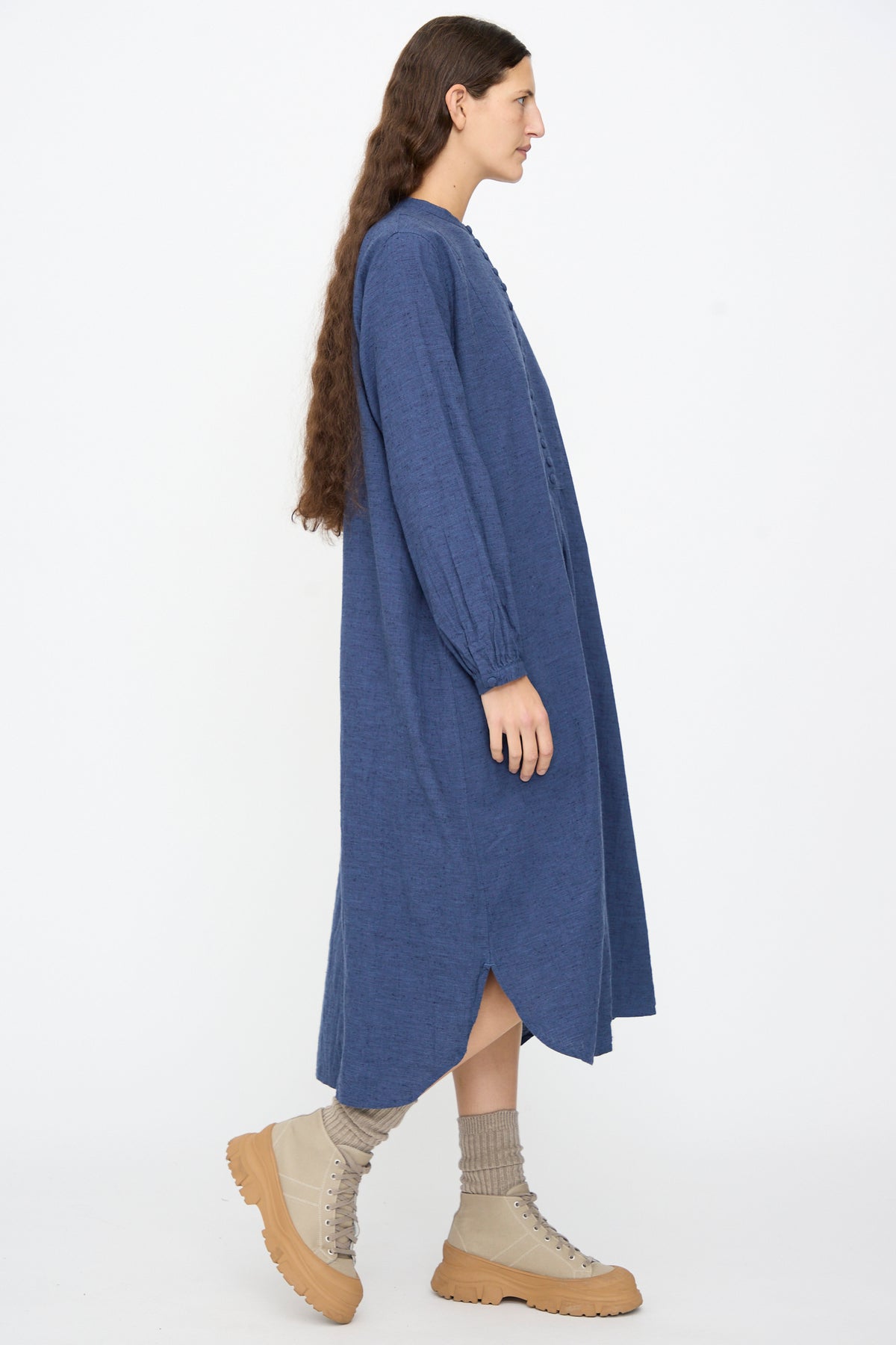A woman wearing an Ichi Antiquités Cotton Linen Nep Dress in navy, featuring a high collar and midi length, paired with ribbed socks and tan lace-up boots with chunky soles.
