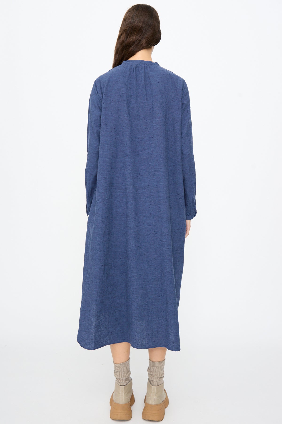 A person viewed from behind wearing an Ichi Antiquités Cotton Linen Nep Dress in Navy, tan socks, and tan shoes.