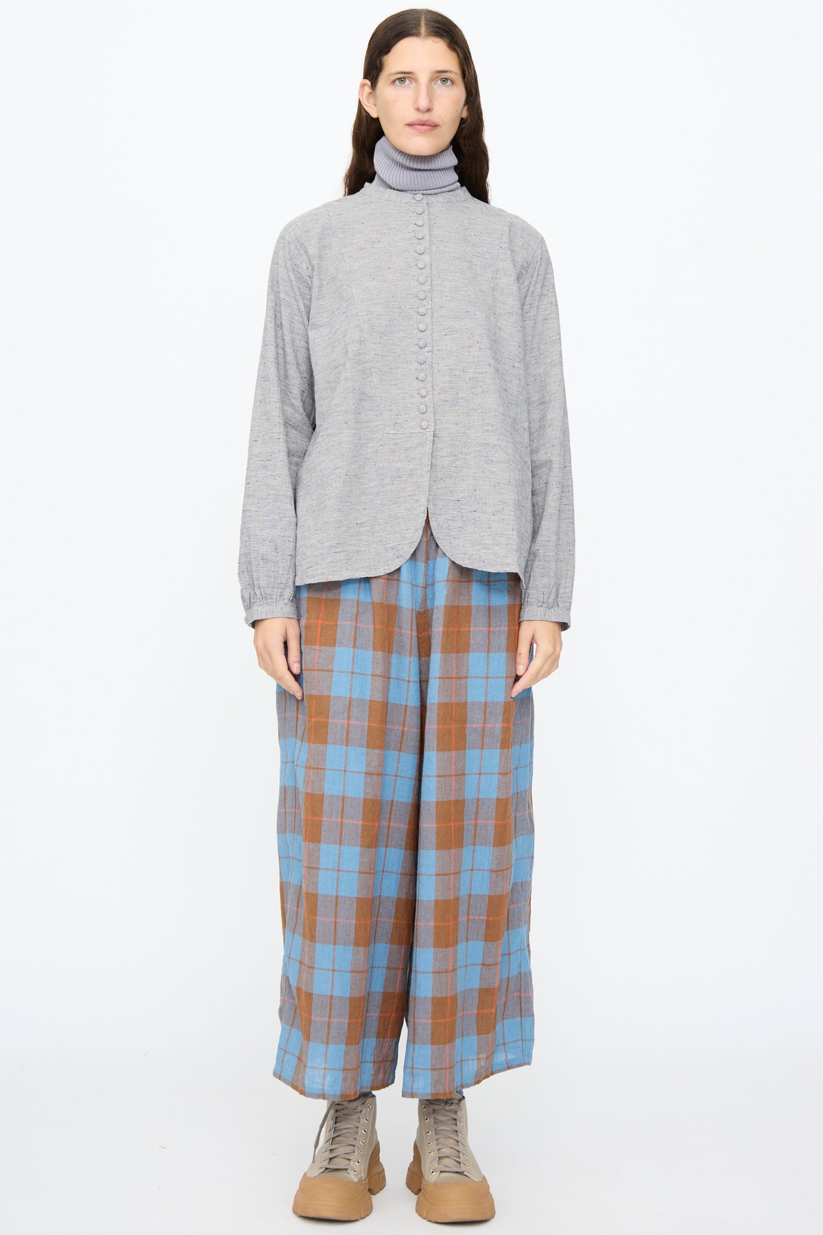 A model wears an Ichi Antiquités Cotton Linen Nep Shirt in Natural over a turtleneck, paired with blue and brown plaid wide-leg trousers and beige platform sneakers.