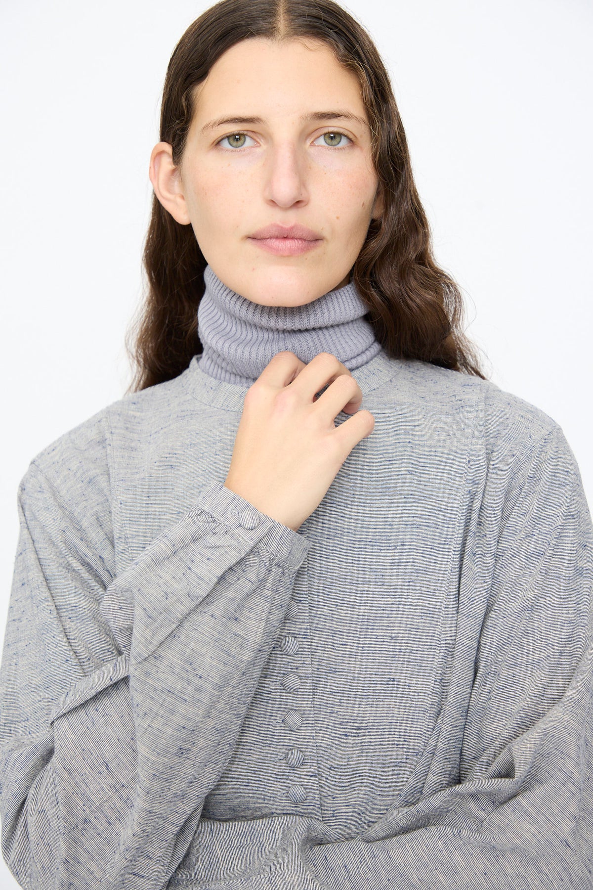 A person wears a grey mock-neck top under a blue, textured Ichi Antiquités Cotton Linen Nep Shirt.